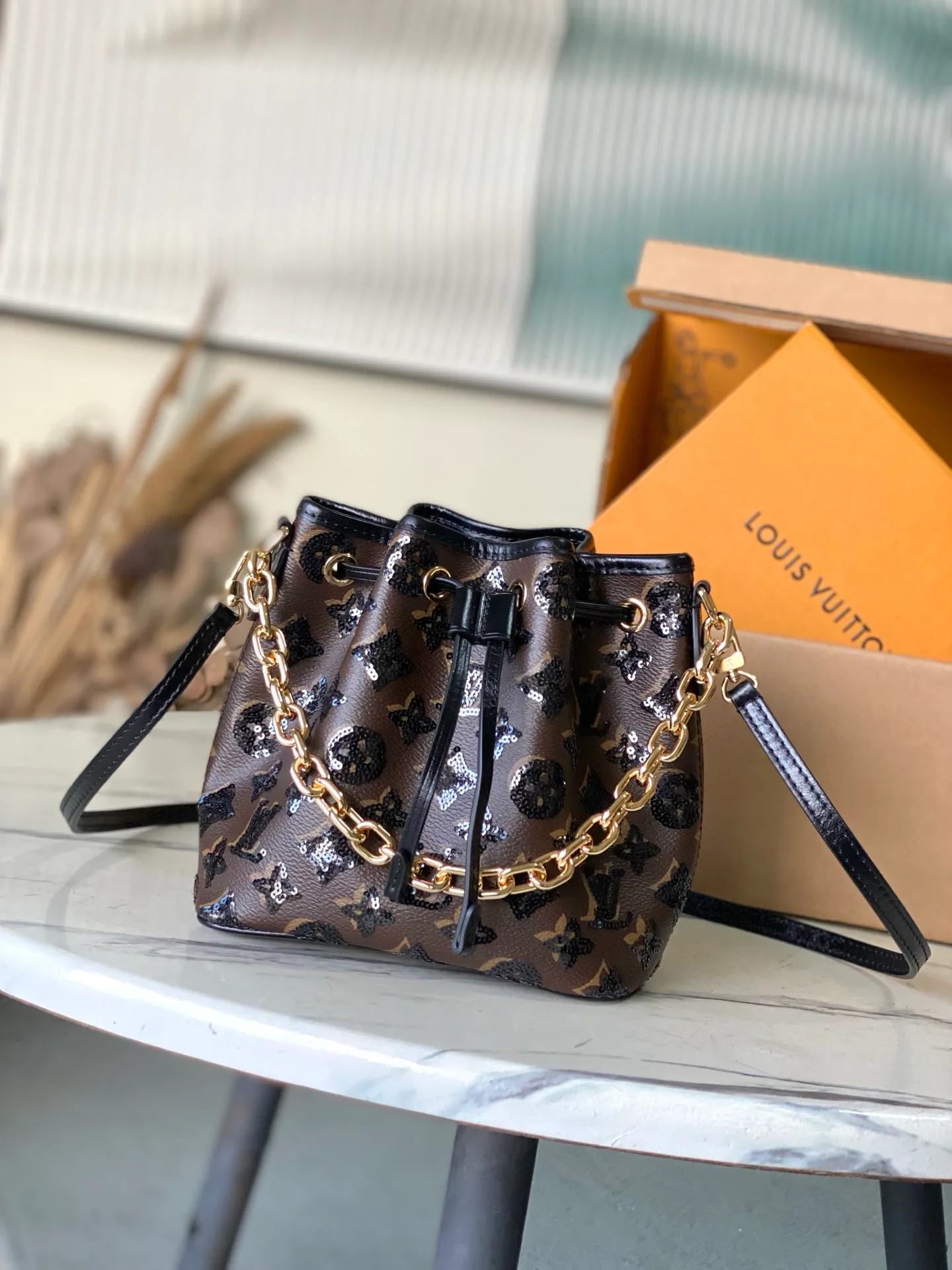 💰1180 Top original order M26284 This NoeBB handbag is from the LVSki series. The canvas body is decorated with bright Monogram pattern sequins. The glossy appearance is suitable for attending night occasions in the countryside and the city. The dazzling thick chain reinterprets the original 1932 configuration, and is just the right size to store your favorite lipstick and other personal items. Dimensions: 22 × 17.5 × 13 cm