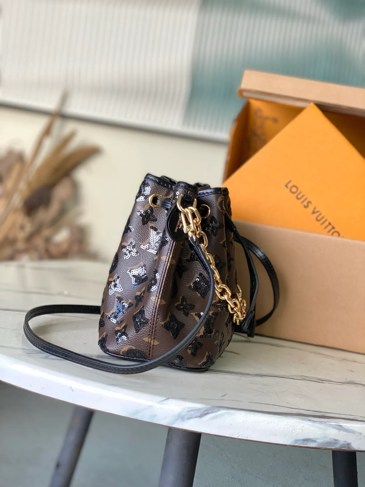 💰1180 Top original order M26284 This NoeBB handbag is from the LVSki series. The canvas body is decorated with bright Monogram pattern sequins. The glossy appearance is suitable for attending night occasions in the countryside and the city. The dazzling thick chain reinterprets the original 1932 configuration, and is just the right size to store your favorite lipstick and other personal items. Dimensions: 22 × 17.5 × 13 cm