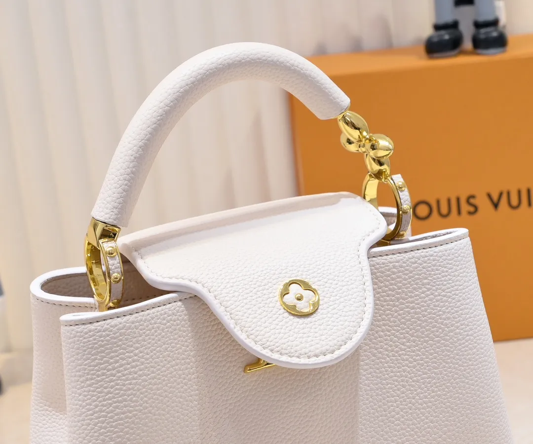 The upgraded version of the P460 M24698 Capucines BB handbag is made of Taurillon cow leather decorated with shiny metal parts, and the LV letters are written in 3D strokes. Metal Monogram flowers bloom quietly on the rolled leather handle, subtly proving the brand's exquisite craftsmanship. The detachable and adjustable leather shoulder strap allows for comfortable shoulder carrying. Detailed features 26.5 x17.5 x9 cm