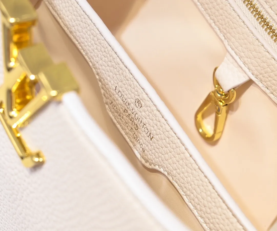 The upgraded version of the P460 M24698 Capucines BB handbag is made of Taurillon cow leather decorated with shiny metal parts, and the LV letters are written in 3D strokes. Metal Monogram flowers bloom quietly on the rolled leather handle, subtly proving the brand's exquisite craftsmanship. The detachable and adjustable leather shoulder strap allows for comfortable shoulder carrying. Detailed features 26.5 x17.5 x9 cm