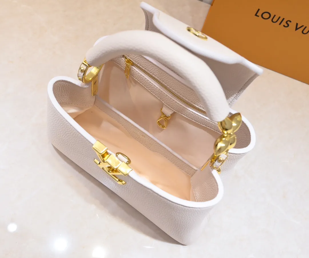 The upgraded version of the P460 M24698 Capucines BB handbag is made of Taurillon cow leather decorated with shiny metal parts, and the LV letters are written in 3D strokes. Metal Monogram flowers bloom quietly on the rolled leather handle, subtly proving the brand's exquisite craftsmanship. The detachable and adjustable leather shoulder strap allows for comfortable shoulder carrying. Detailed features 26.5 x17.5 x9 cm
