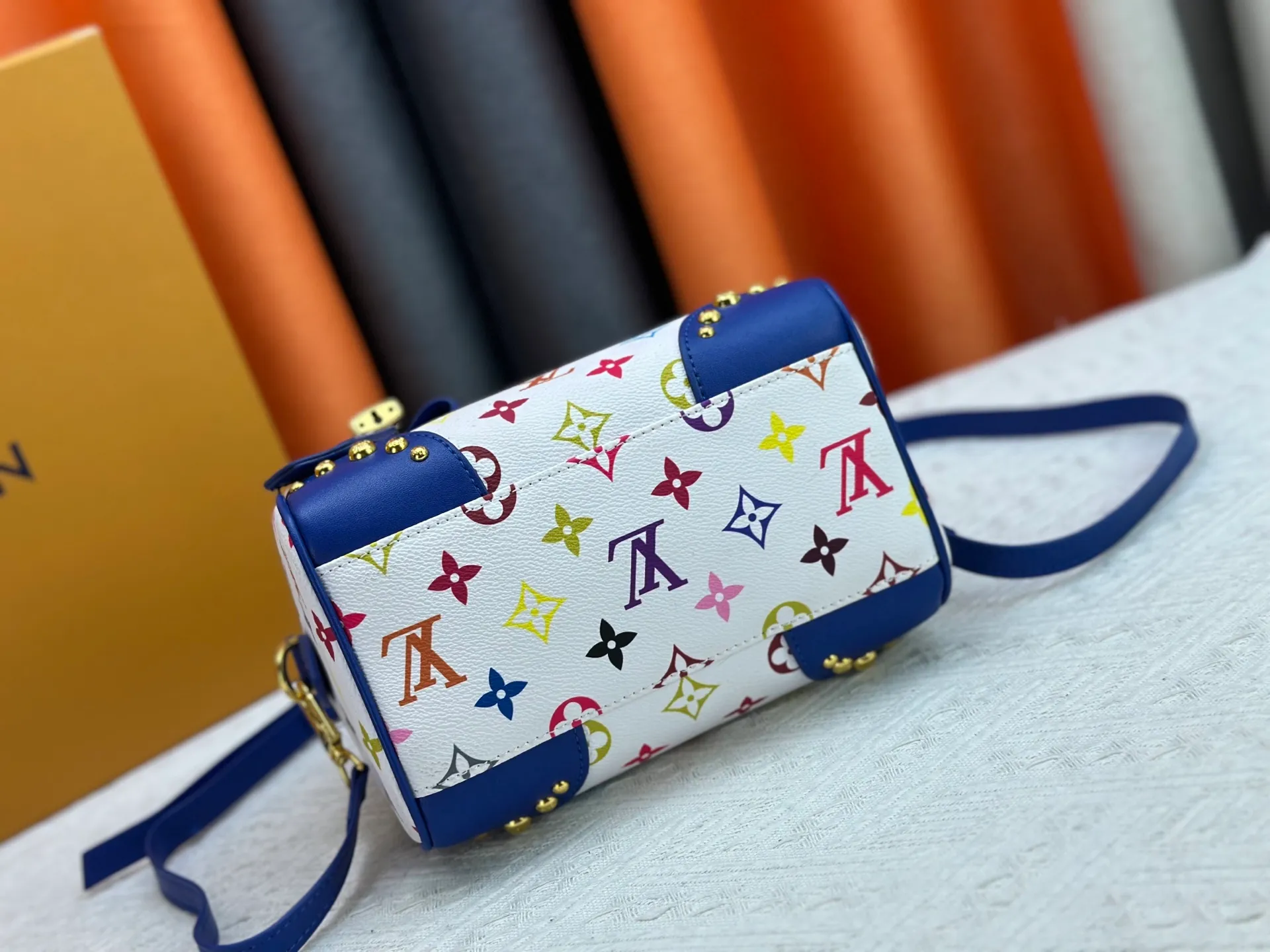 P260 upgraded original M58953 M46234 M46222 Speedy Bandoulière 20 handbag is made of soft coated canvas, and the full-length Monogram pattern is traced in colorful rainbow tones, highlighting the smart style of the Louis Vuitton x Murakami reissue series. The Toron handle and detachable shoulder strap are constructed of cow leather, the metal corners recall classic luggage elements, and the bow-shaped key bag and padlock add brand touches. Dimensions: 20.5 x 13.5 x 12.0 cm (length x height x width)