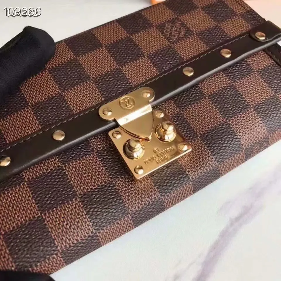 P160N60535 Material: PVC with cowhide leather Size: 21/10 Crafted from Damier Ebene canvas and decorated with the iconic S lock and rivets, this stylish Venice wallet pays homage to Louis Vuitton’s rich heritage as a luxury luggage manufacturer. Thanks to its spacious and functional interior, this model can also be used as an elegant clutch.