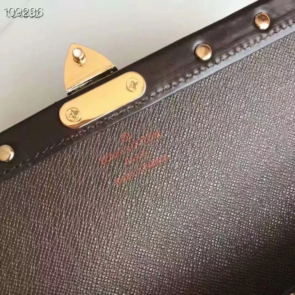 P160N60535 Material: PVC with cowhide leather Size: 21/10 Crafted from Damier Ebene canvas and decorated with the iconic S lock and rivets, this stylish Venice wallet pays homage to Louis Vuitton’s rich heritage as a luxury luggage manufacturer. Thanks to its spacious and functional interior, this model can also be used as an elegant clutch.