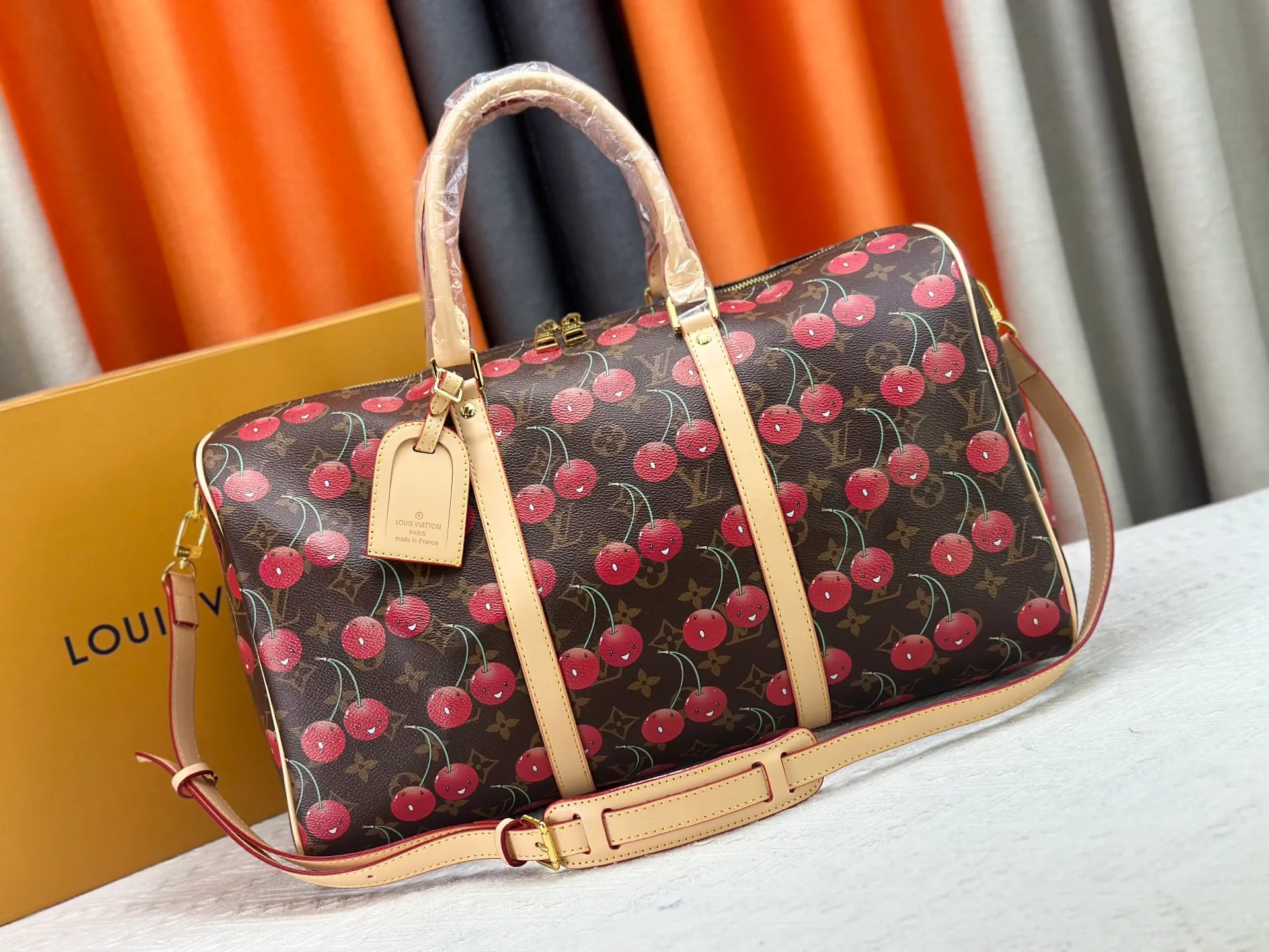 P380 M13764 M41416 Keepall Bandoulière 45 travel bag gets a new look with the Louis Vuitton x Takashi Murakami retro series. Classic Monogram canvas features a patchwork pattern of sweet cherries and a bold lining that reflects the playful aesthetic of renowned Japanese artist Takashi Murakami. Side straps, top handles and adjustable shoulder straps reveal the natural color of the leather, while dazzling hardware completes the look.  27 x 20 x 45 cm (H x W x L) Carry-on dimensions Monogram coated canvas Cow leather trim Textile lining Metal hardware Double zipper closure Internal zip pocket Padlock Designer tag, hot stampable Shoulder strap: removable, adjustable Half-length strap: 36.0 cm Half-length strap adjustable to: 50.0 cm Handle: Double handle