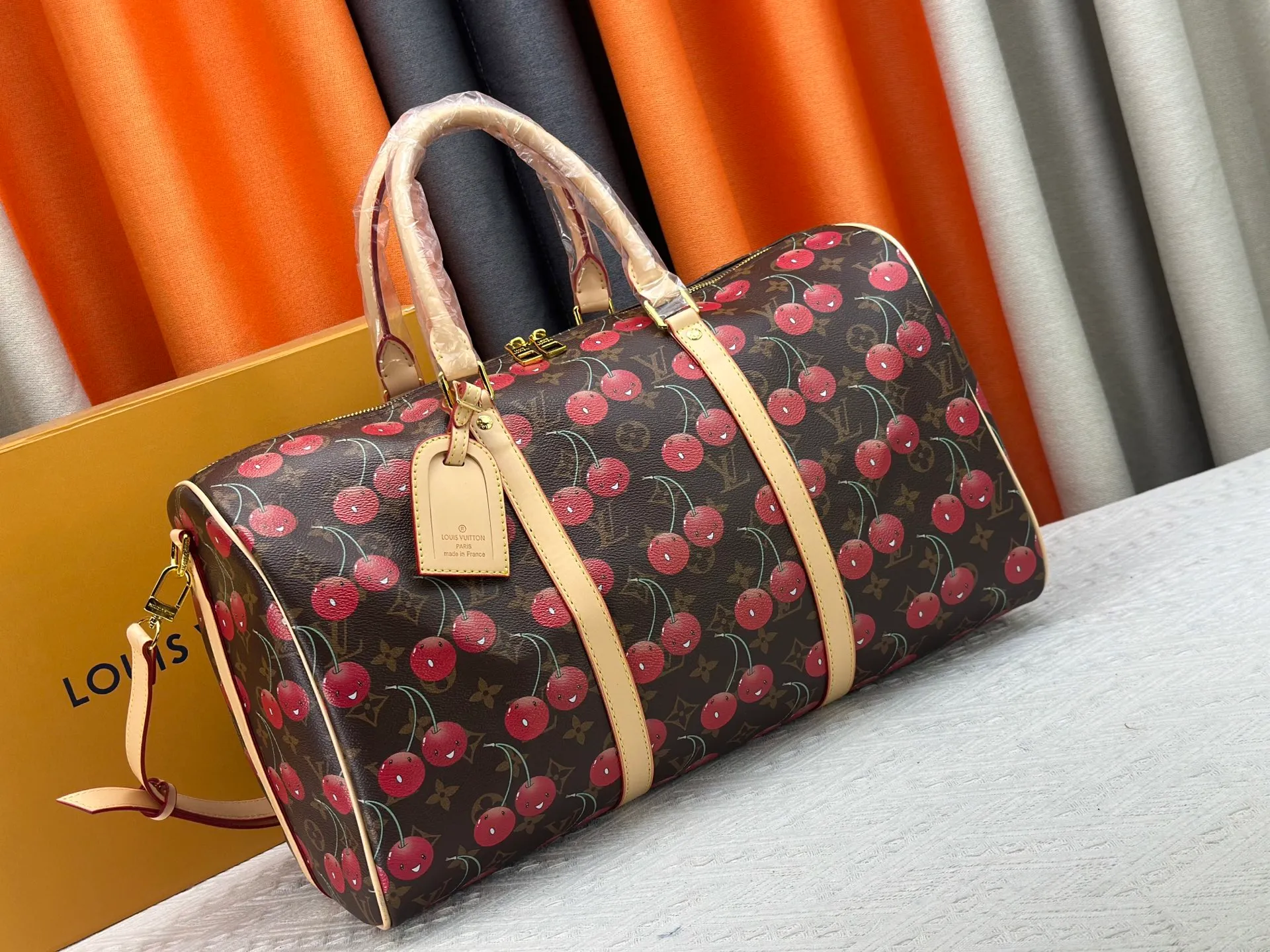 P380 M13764 M41416 Keepall Bandoulière 45 travel bag gets a new look with the Louis Vuitton x Takashi Murakami retro series. Classic Monogram canvas features a patchwork pattern of sweet cherries and a bold lining that reflects the playful aesthetic of renowned Japanese artist Takashi Murakami. Side straps, top handles and adjustable shoulder straps reveal the natural color of the leather, while dazzling hardware completes the look.  27 x 20 x 45 cm (H x W x L) Carry-on dimensions Monogram coated canvas Cow leather trim Textile lining Metal hardware Double zipper closure Internal zip pocket Padlock Designer tag, hot stampable Shoulder strap: removable, adjustable Half-length strap: 36.0 cm Half-length strap adjustable to: 50.0 cm Handle: Double handle