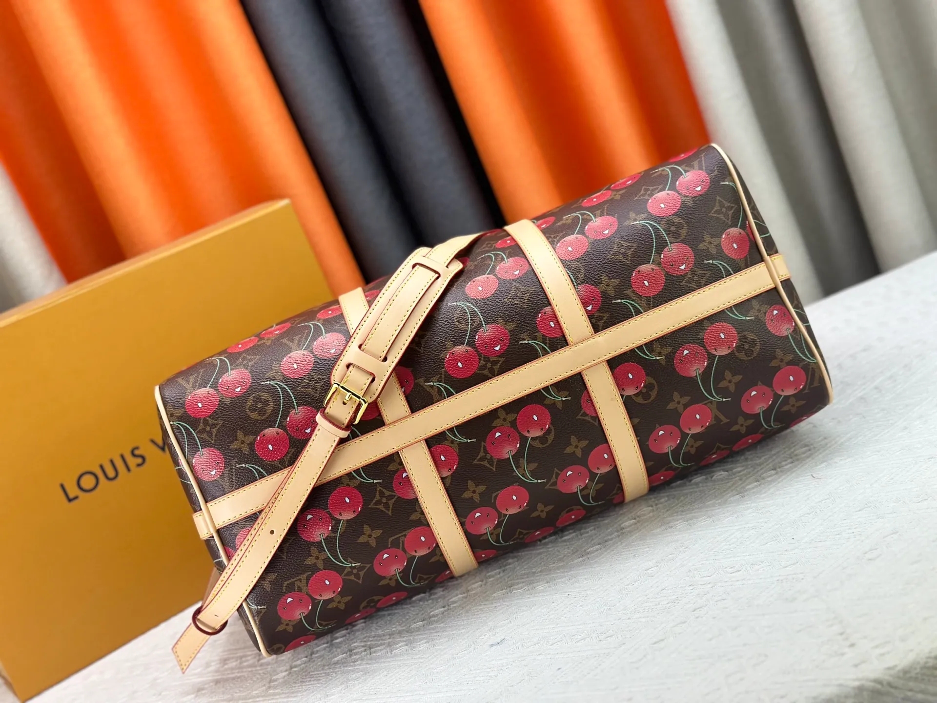 P380 M13764 M41416 Keepall Bandoulière 45 travel bag gets a new look with the Louis Vuitton x Takashi Murakami retro series. Classic Monogram canvas features a patchwork pattern of sweet cherries and a bold lining that reflects the playful aesthetic of renowned Japanese artist Takashi Murakami. Side straps, top handles and adjustable shoulder straps reveal the natural color of the leather, while dazzling hardware completes the look.  27 x 20 x 45 cm (H x W x L) Carry-on dimensions Monogram coated canvas Cow leather trim Textile lining Metal hardware Double zipper closure Internal zip pocket Padlock Designer tag, hot stampable Shoulder strap: removable, adjustable Half-length strap: 36.0 cm Half-length strap adjustable to: 50.0 cm Handle: Double handle