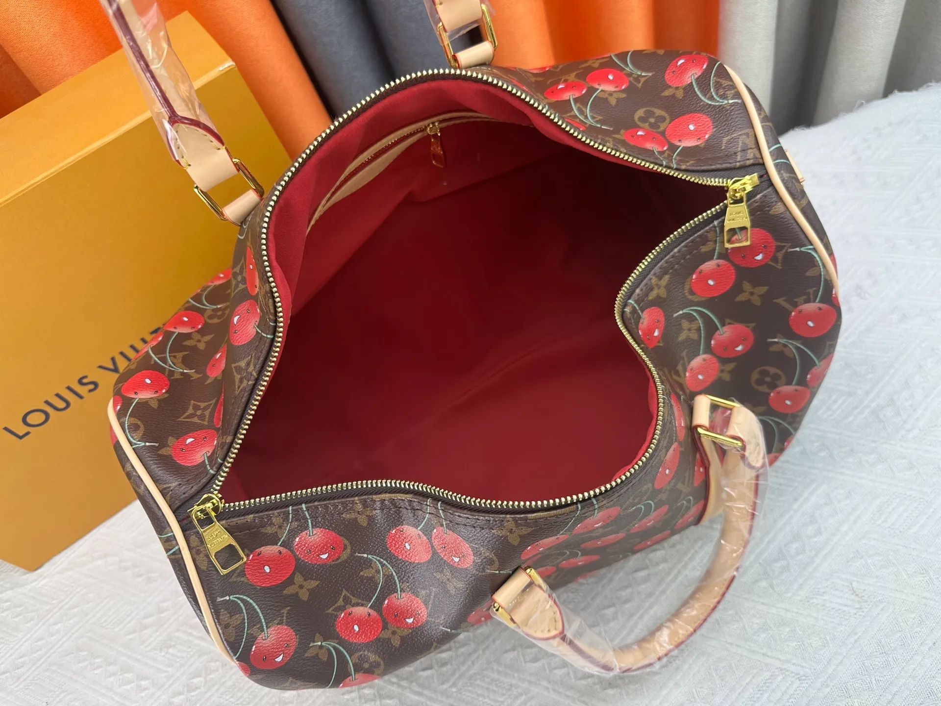 P380 M13764 M41416 Keepall Bandoulière 45 travel bag gets a new look with the Louis Vuitton x Takashi Murakami retro series. Classic Monogram canvas features a patchwork pattern of sweet cherries and a bold lining that reflects the playful aesthetic of renowned Japanese artist Takashi Murakami. Side straps, top handles and adjustable shoulder straps reveal the natural color of the leather, while dazzling hardware completes the look.  27 x 20 x 45 cm (H x W x L) Carry-on dimensions Monogram coated canvas Cow leather trim Textile lining Metal hardware Double zipper closure Internal zip pocket Padlock Designer tag, hot stampable Shoulder strap: removable, adjustable Half-length strap: 36.0 cm Half-length strap adjustable to: 50.0 cm Handle: Double handle