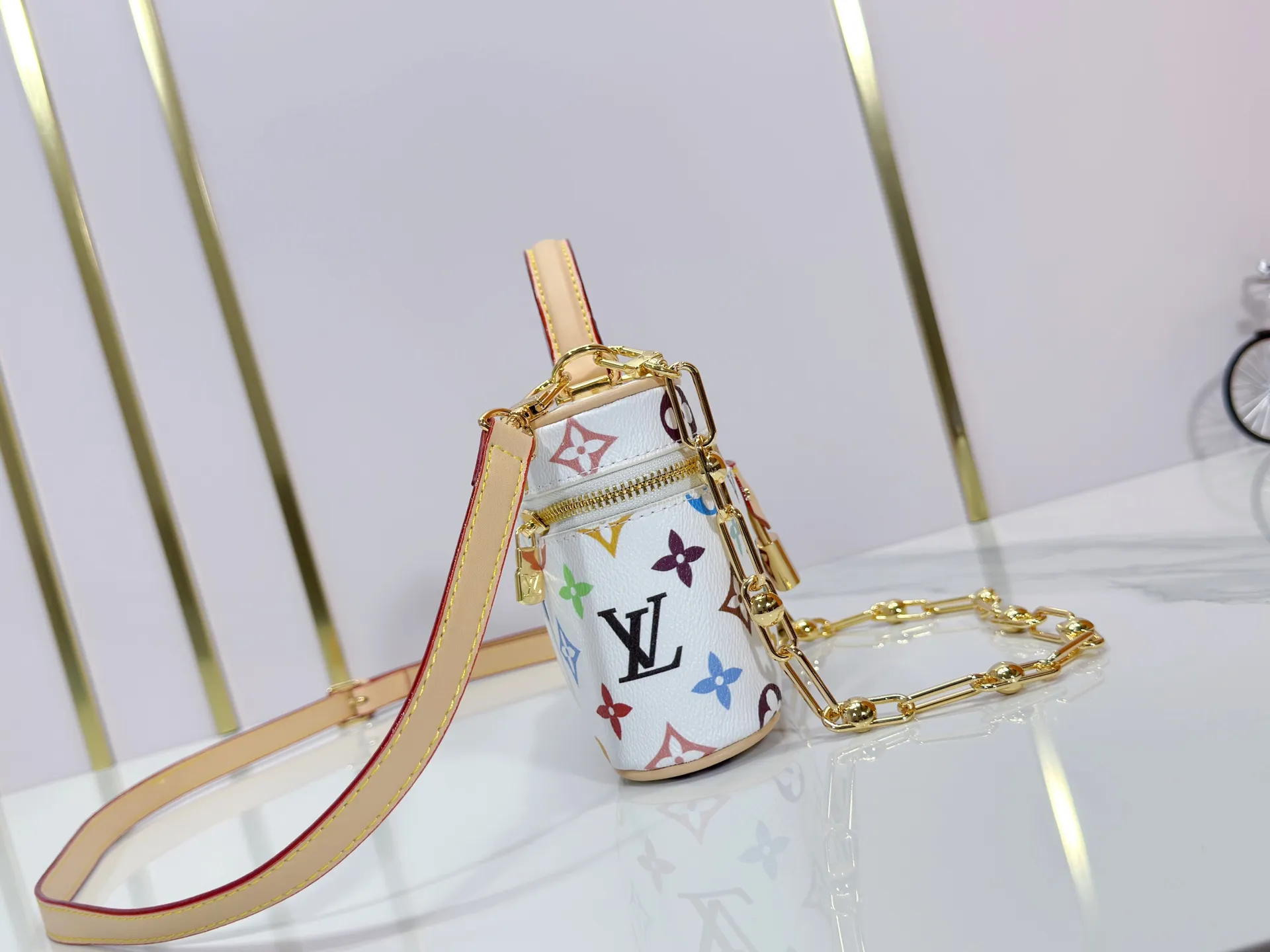 P280 Upgraded original M13662 This Vanity Pouch handbag is from the Louis Vuitton x Takashi Murakami reissue series, reinterpreting the brand's classic Monogram pattern with the artist's distinctive tones. Coated canvas is trimmed with calfskin, while a zipper closure, detachable chain and LV-engraved padlock add a metallic sheen. Dimensions: 11.5 x 6.5 x 19 cm (height x width x length)