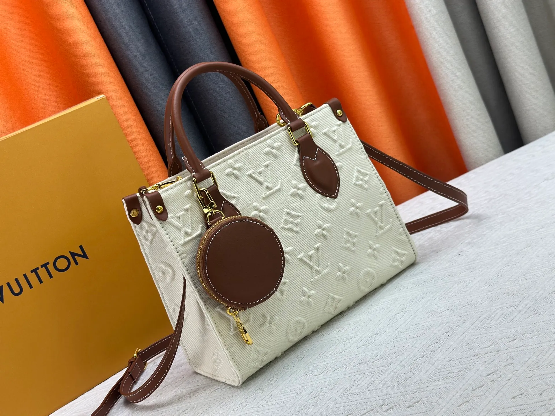 P300 M45659 M46373 Apricot embossed denim OnTheGo small new version The legendary ONTHEGO handbag: made of washed LV Blason denim, with deep tones to accentuate the gradient effect of the LV letters, showing Pharrell Williams' creative ingenuity in translating graceful music into fashion language. The zippered front pocket provides easy access to everyday items, while the drawstring closure and magnetic laces provide ample space. Detailed features25x11x19 cm