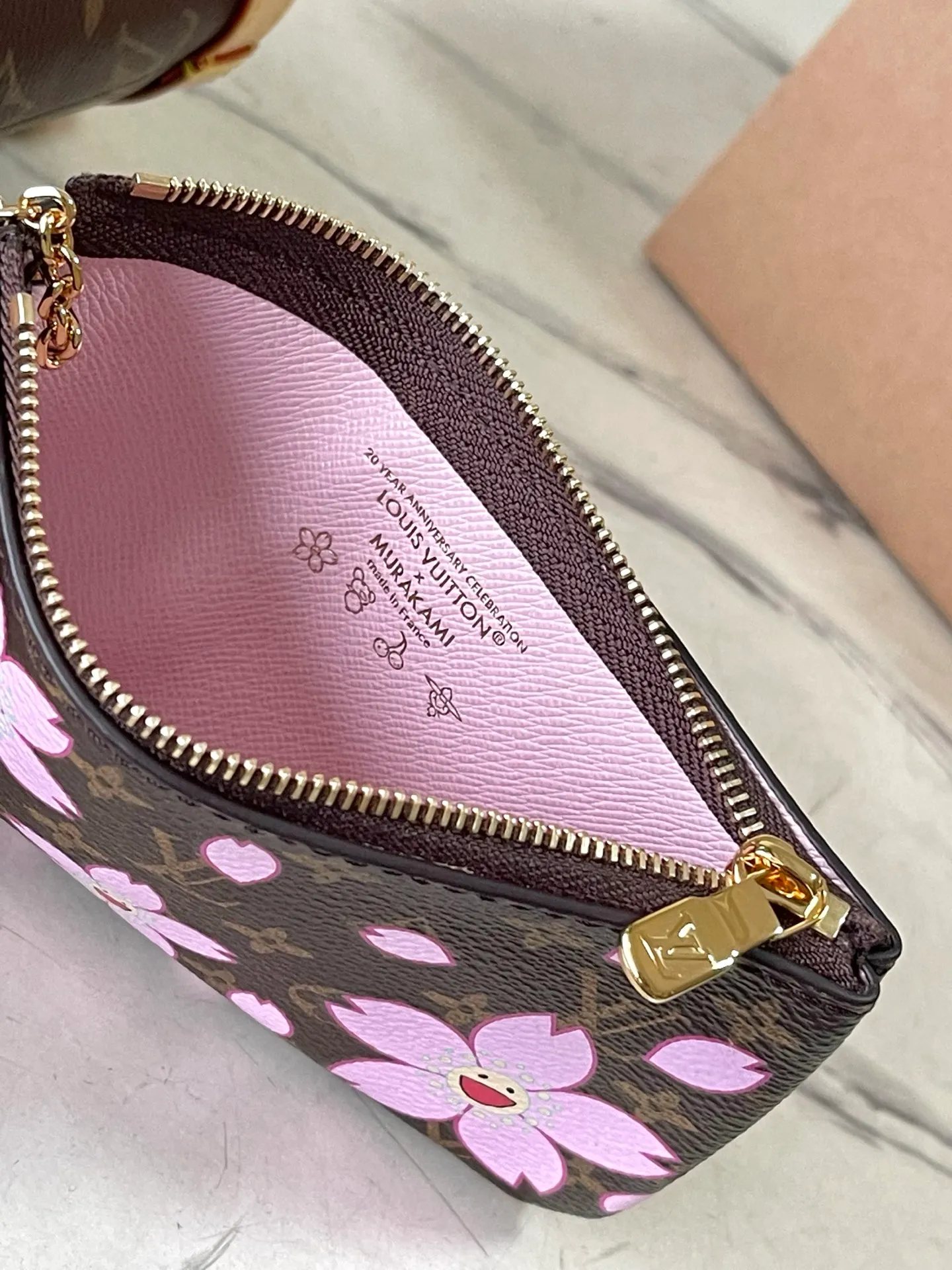 💰900 Top Original Order M13417 This Nano Bucket handbag is constructed of classic Monogram coated canvas with a sophisticated design, and is completed with cow leather trim and dazzling metal parts. The Cherry Blossom pattern on the body of the bag conveys the atmosphere of prosperous recovery and highlights the distinctive style of Japanese artist Takashi Murakami. The detachable shoulder strap allows for a variety of carrying options, and the leather keychain adds a functional detail. Dimensions: 13 × 17 × 9 cm