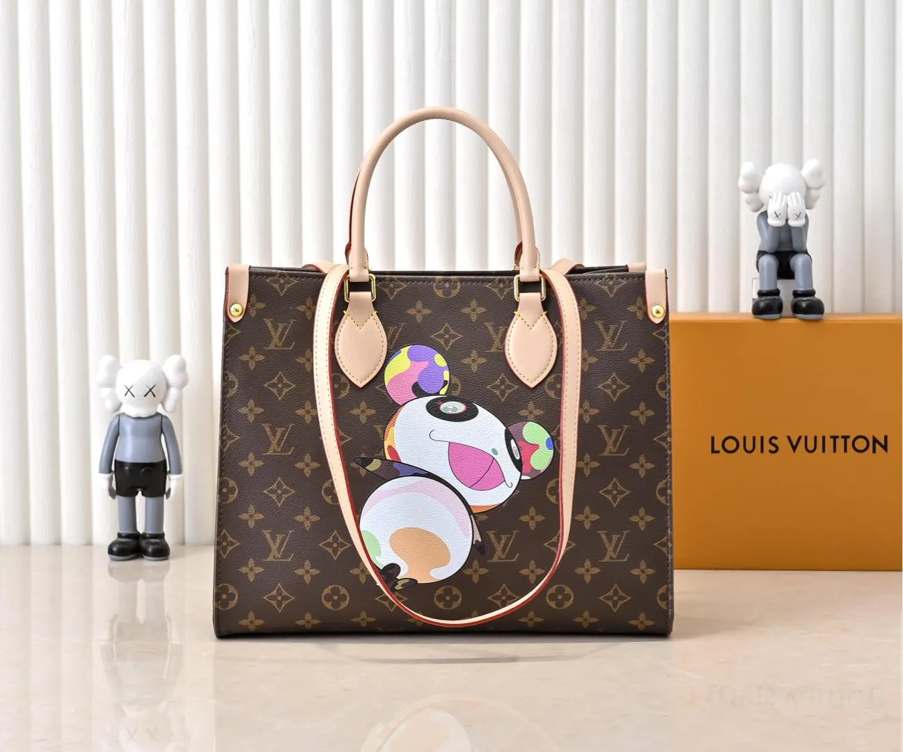 Batch 320💰M45039 M13668!🔥Lv&Takashi Murakami🐼Panda print OnTheGo new version The legendary ONTHEGO handbag: always able to meet your various needs for handbags. It has a large capacity but is not bulky. It is stiff and soft to the touch, making it suitable for home and travel. Tighten the side ties and it instantly transforms into a stylish urban handbag. Loosen the straps and it transforms into a chic and practical handbag. The slender leather handle can be carried over the shoulder or between the arms. The model shown here is made of Damier Azur canvas. Size: 35x27x14cm