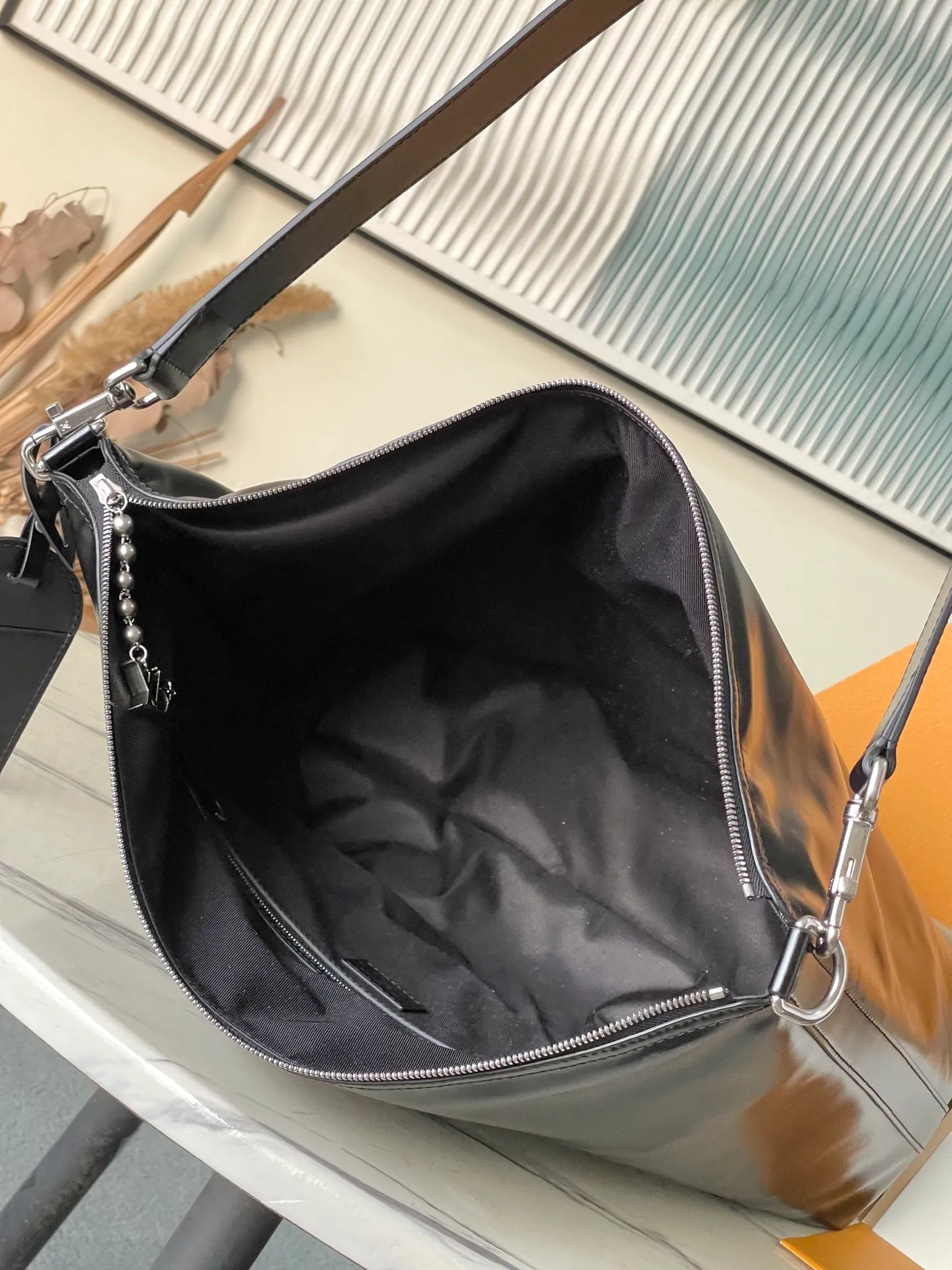 💰1380 (top-grain leather) top original order M13986 This Vagabond Hobo handbag is made of glossy soft cow leather to create an ergonomic and close-fitting silhouette. Whether it is carried cross-body or on the shoulder, it can show its cool style. The metal zipper enables smooth opening and closing, and the bead chain cleverly connects the zipper puller and V letter decoration. Dimensions: 35×12×38 cm