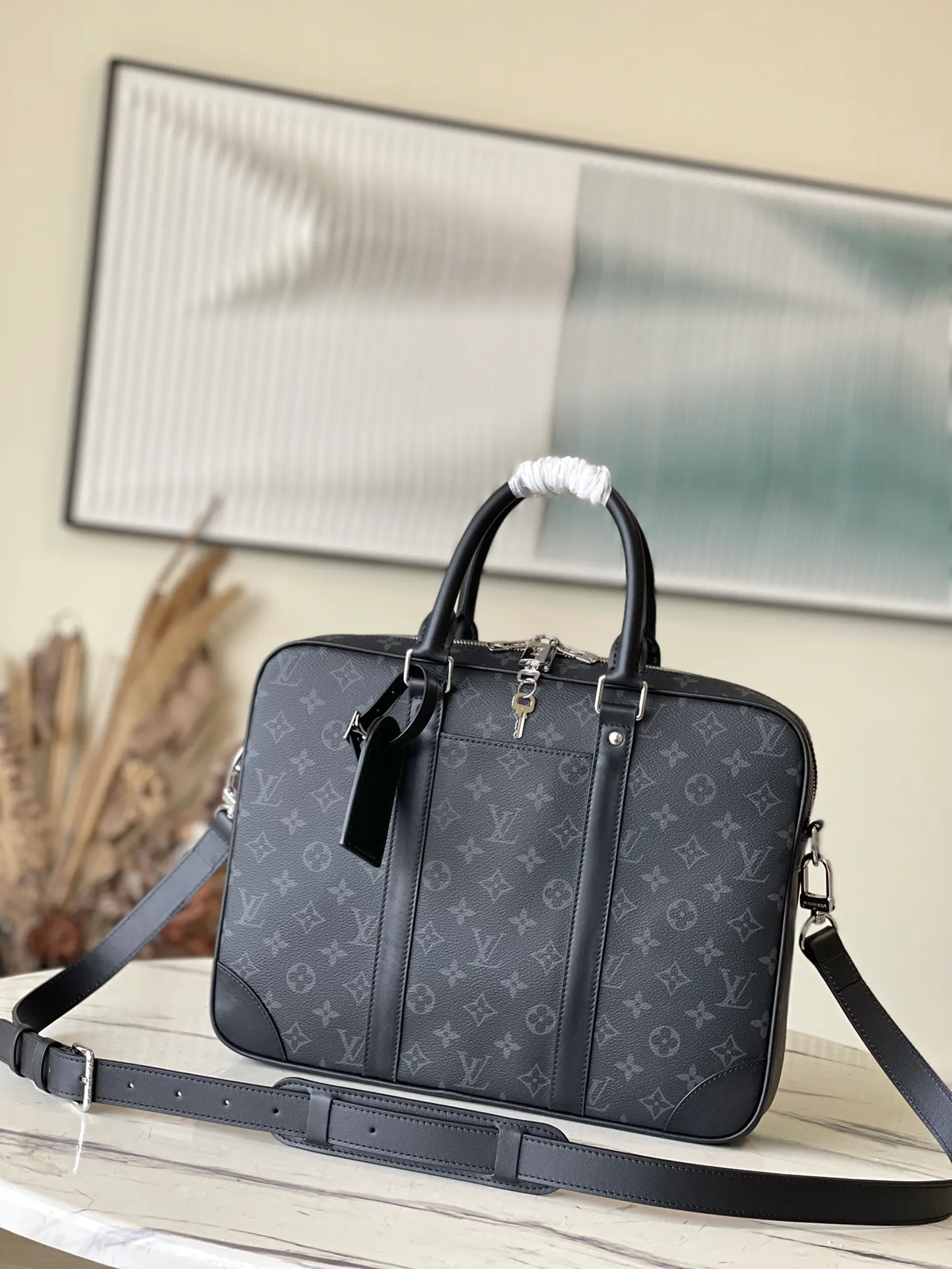 💰1000 Top Original M46457 This Voyage small briefcase is made of Damier Graphite coated canvas, with leather side straps, reinforced corners, top handles and nameplate. The outer pocket makes it easy to store a smartphone, the padded interior compartment holds a 13-inch laptop, and the removable and adjustable shoulder strap makes it comfortable to carry over the shoulder. Dimensions: 36.5 x 27.5 x 6 cm