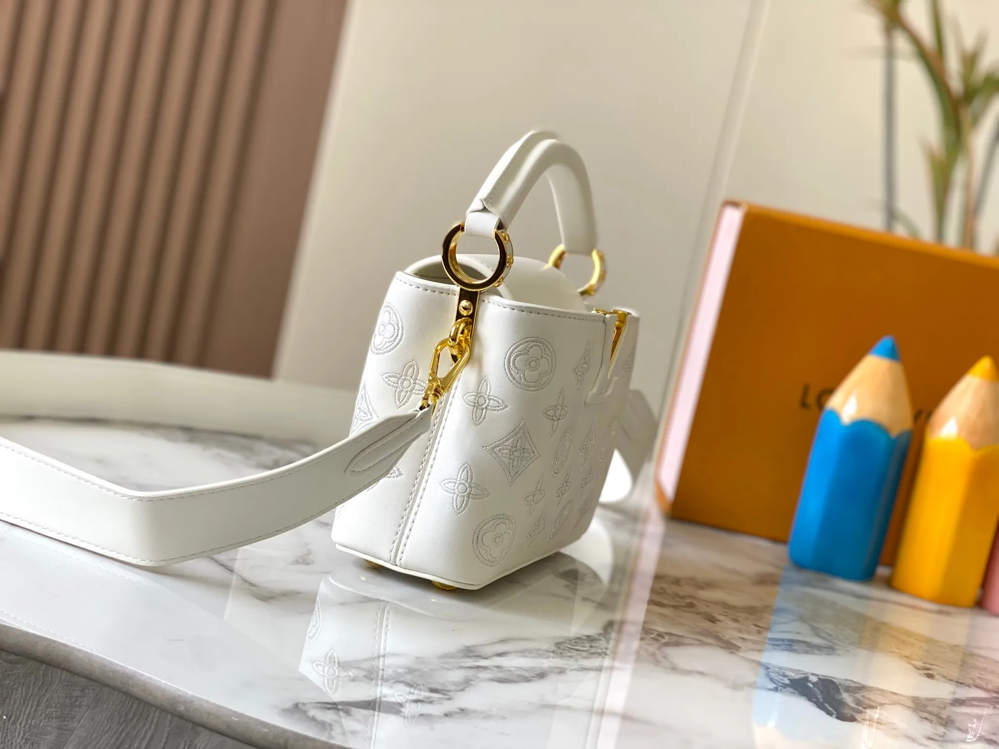 Upgraded version P440 M20741 Bourdon stitch embroidered gold buckle This Capucines mini handbag comes from the LV Broderie Anglaise capsule series designed by Nicolas Ghesquière, which transfers the embroidery technology in the ready-to-wear series to this. For the first time, the Monogram pattern appears on cow leather through cutting, and is embellished with Bourdon stitching, which is exquisitely crafted with craftsmanship.  Detailed features 21 x 14 x8 cm (length x height x width)