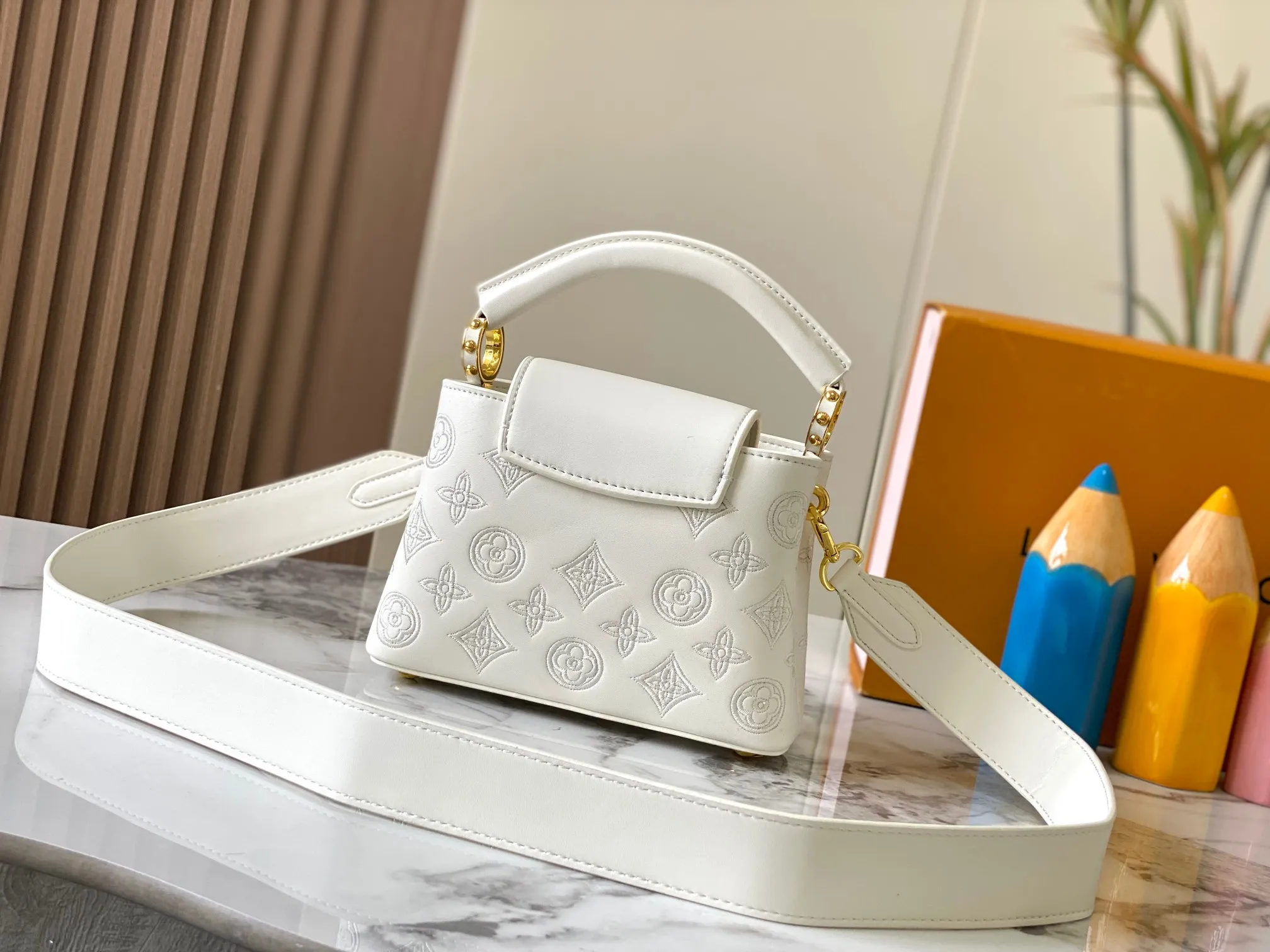 Upgraded version P440 M20741 Bourdon stitch embroidered gold buckle This Capucines mini handbag comes from the LV Broderie Anglaise capsule series designed by Nicolas Ghesquière, which transfers the embroidery technology in the ready-to-wear series to this. For the first time, the Monogram pattern appears on cow leather through cutting, and is embellished with Bourdon stitching, which is exquisitely crafted with craftsmanship.  Detailed features 21 x 14 x8 cm (length x height x width)