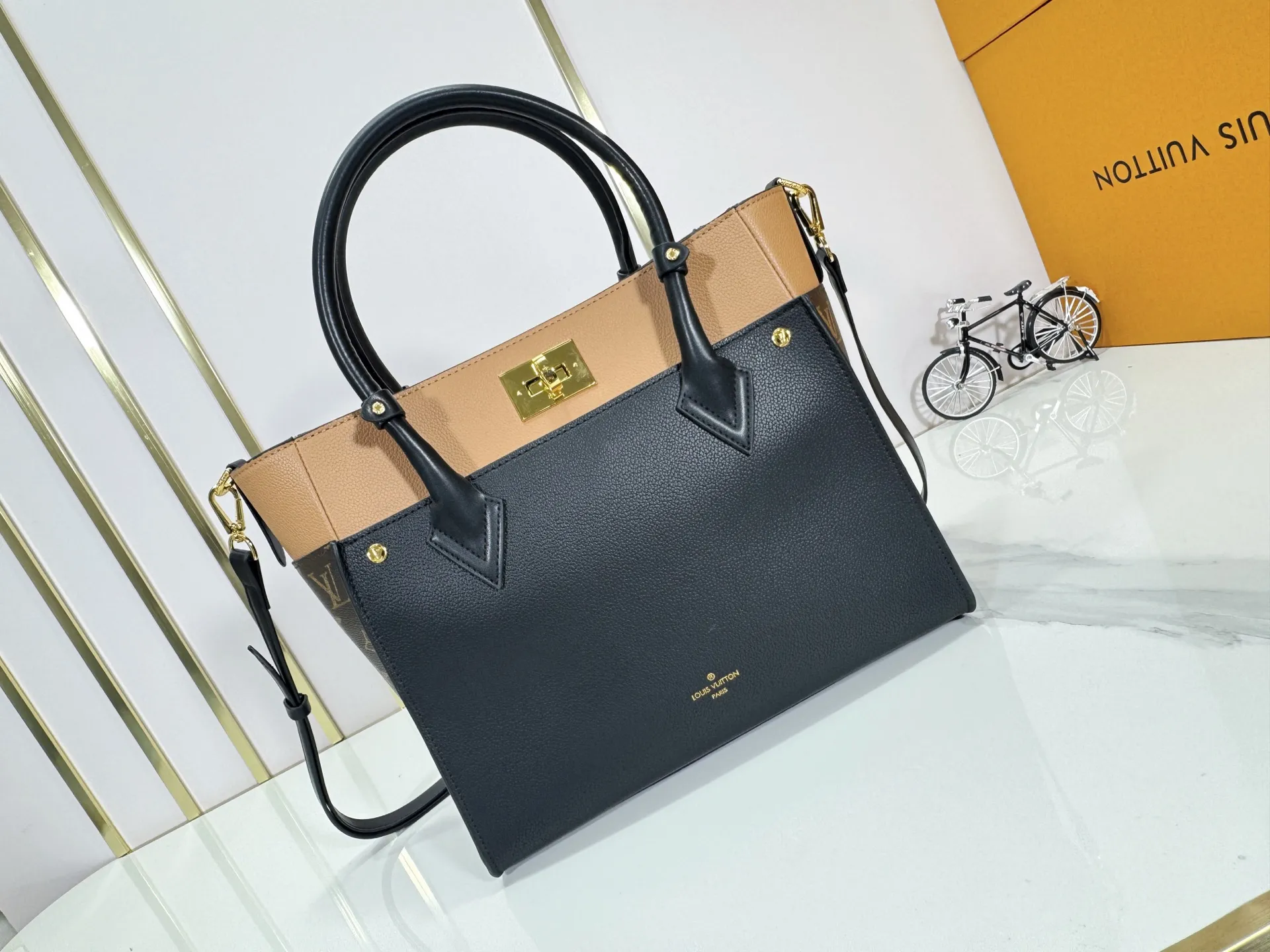 P360 upgraded original M53826 M53826 M53825 M53824 M53823On My Side handbag shows the elegant fusion of calfskin and classic Monogram canvas. Contrasting canvas shapes the large outer pocket, creating a trompe l'oeil effect as if two handbags merge into one. Plenty of space can easily accommodate office needs, and the adjustable shoulder strap allows for a cross-body style. Dimensions: 30.5 x 24.5 x 14 cm (Length x Height x Width) - Calfskin and Monogram coated canvas - Cowhide leather trim - Microfiber lining - 2 top handles for hand or elbow carry - Adjustable shoulder strap for shoulder or cross-body wear - Lock closure - 2 outer pockets with magnetic closure - Zip pocket - 1 patch pocket
