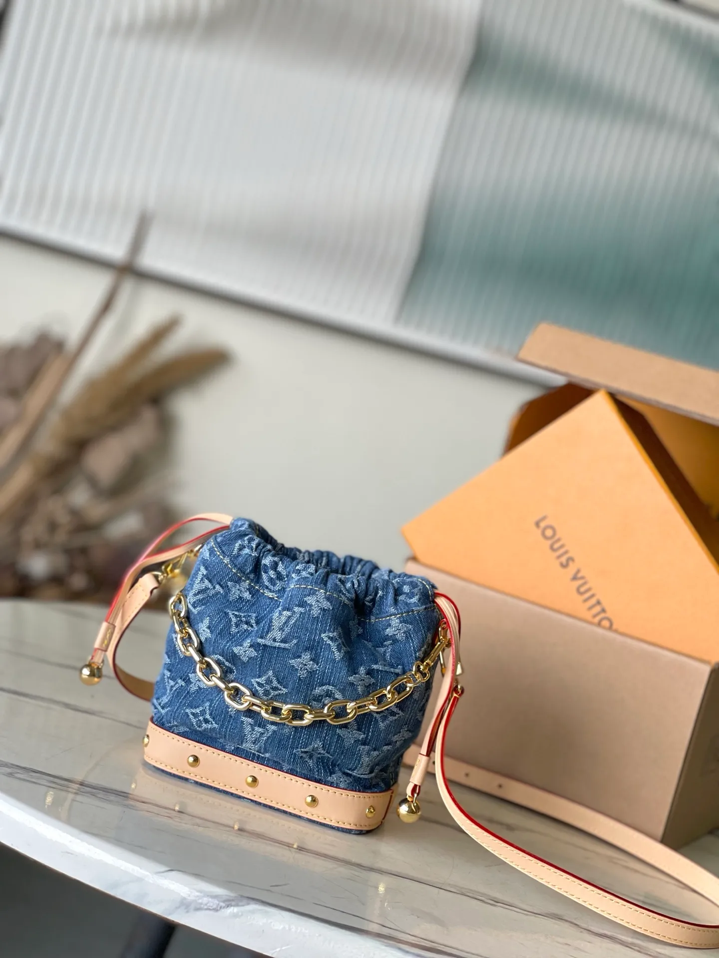💰900 Top Original M83043 This NanoNoe backpack is made of cotton with trendy denim tones, and the classic Monogram pattern is laid out on it, which contrasts with the leather trim and dazzling chain. The LV inscription decoration on the drawstring opening and closing reveals a fun style and pays tribute to the brand's long heritage. Dimensions: 20.5 × 17.5 × 8.8 cm