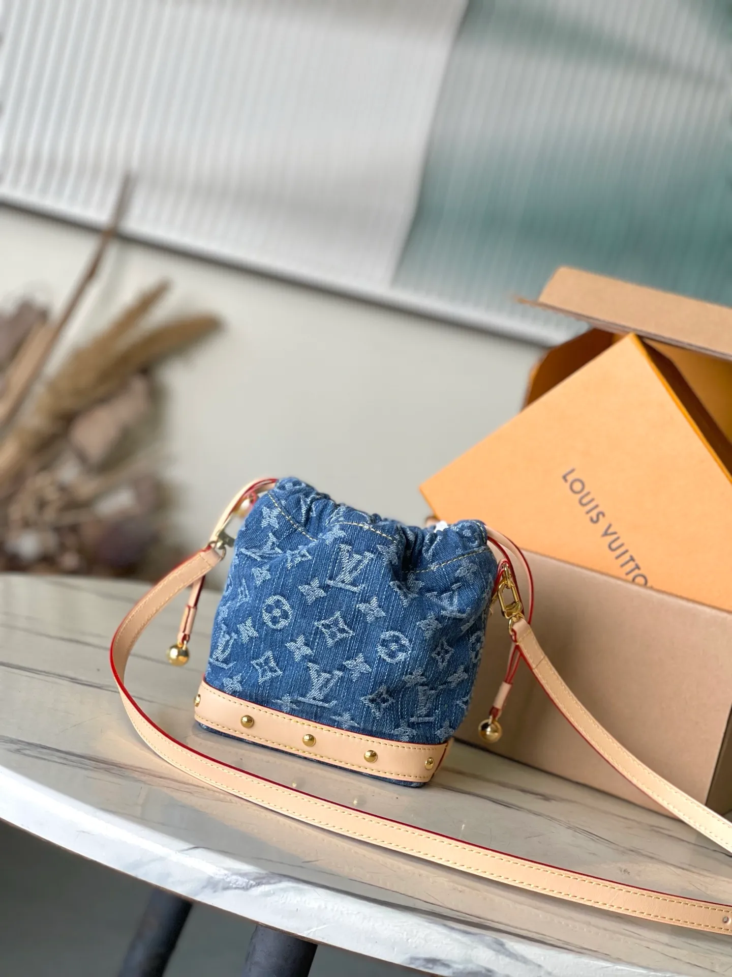💰900 Top Original M83043 This NanoNoe backpack is made of cotton with trendy denim tones, and the classic Monogram pattern is laid out on it, which contrasts with the leather trim and dazzling chain. The LV inscription decoration on the drawstring opening and closing reveals a fun style and pays tribute to the brand's long heritage. Dimensions: 20.5 × 17.5 × 8.8 cm
