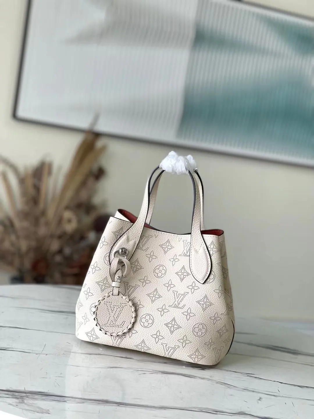💰1060 (top layer leather) top original M21909 milky white Blossom small handbag is made of engraved and perforated cow leather, interpreting practical functions in a leisurely style. The inner compartment is equipped with a detachable zipper bag to easily accommodate daily needs; the handle is convenient for carrying by hand or elbow, and the detachable and adjustable shoulder strap adds shoulder and cross-body options. Dimensions: 20 x 20 x 12.5 cm