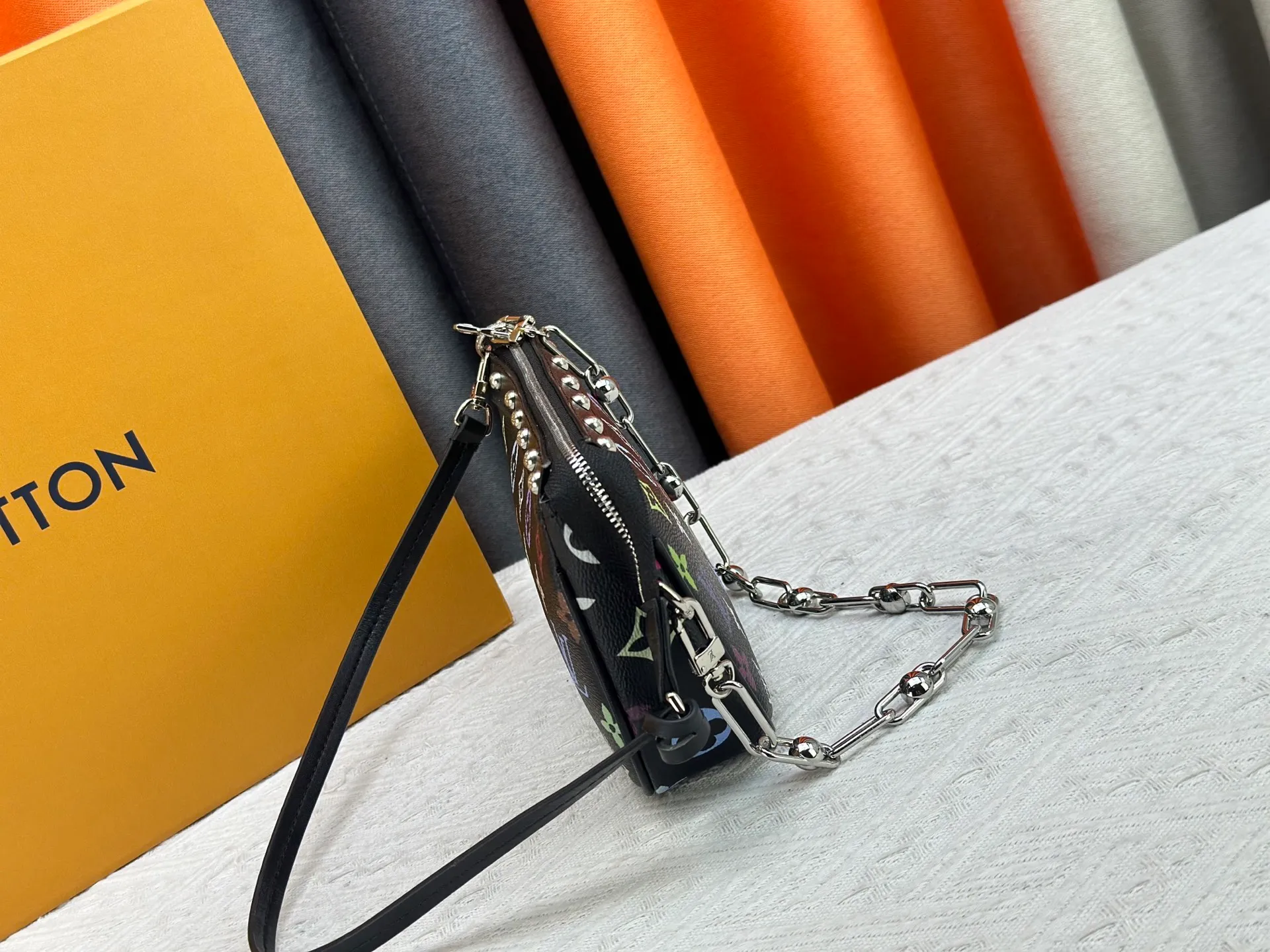 P220 M13404 M13663 Black color White color This Pochette Accessoires handbag is made of coated canvas, with colorful Monogram patterns to interpret the smart style of the Louis Vuitton × Murakami cross-border collaboration series. Calf leather trim and dazzling hardware add to the sophisticated details, while the detachable shoulder strap and chain provide flexible carry. Size: 22x13x4cm