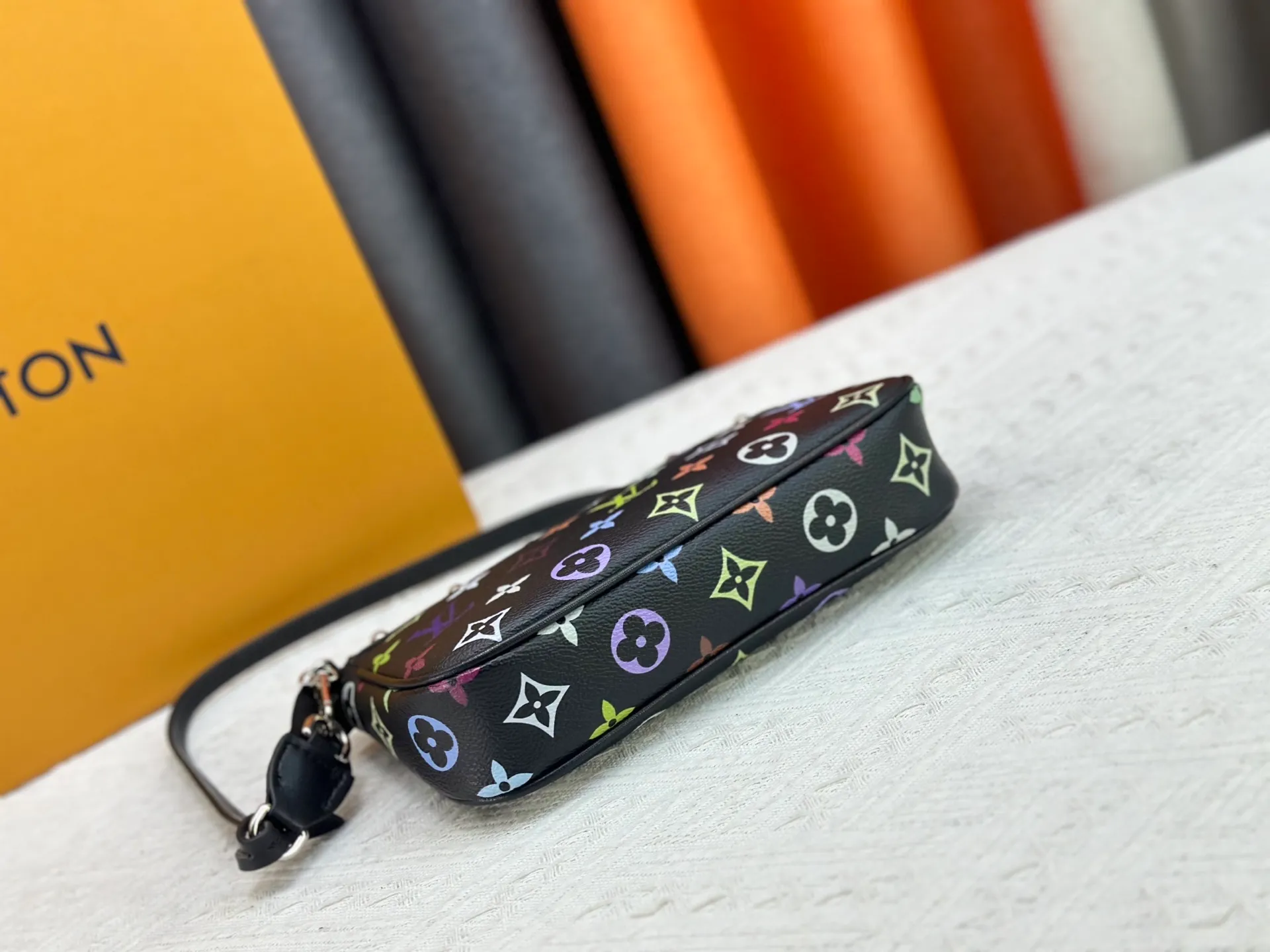 P220 M13404 M13663 Black color White color This Pochette Accessoires handbag is made of coated canvas, with colorful Monogram patterns to interpret the smart style of the Louis Vuitton × Murakami cross-border collaboration series. Calf leather trim and dazzling hardware add to the sophisticated details, while the detachable shoulder strap and chain provide flexible carry. Size: 22x13x4cm