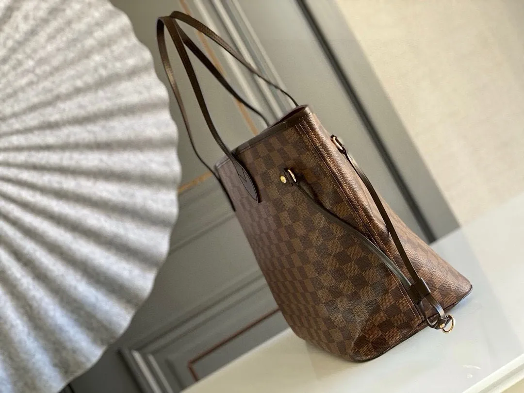 💰760 (Medium Steel Nail) Top Original N41358 NEVERFULL Medium Handbag The legendary Neverfull handbag can always meet your various needs for handbags. It has a large capacity but is not bulky. It is stiff and soft to the touch, making it suitable for home and travel. Tighten the side ties and it instantly transforms into a stylish urban handbag. Loosen the straps and it transforms into a chic and practical handbag. The slender leather handle can be carried over the shoulder or between the arms. The model shown here is made of Damier Ebène canvas.  Detailed Features 31 x 28 x 14 cm (Length x Height x Width) Bag interior redesigned with vintage details inspired by the Louis Vuitton archives - Fabric-lined interior pocket Removable zip clutch with matching interior Natural cowhide leather trim Shiny gold-tone brass hardware Handles: Double handle