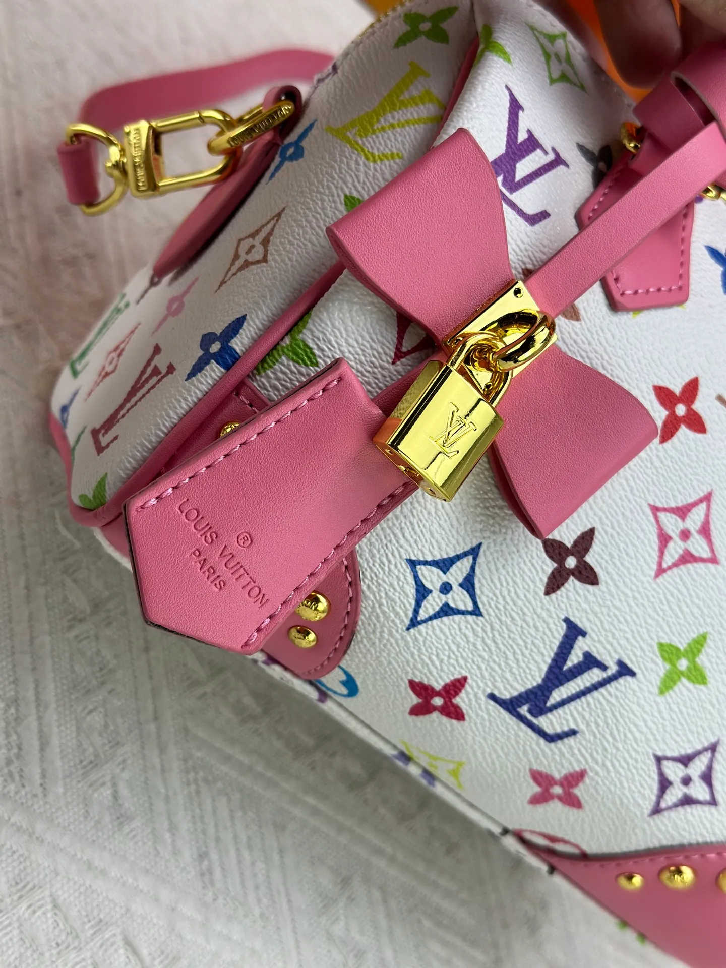 P260 upgraded original M58953 M46234 M46222 Speedy Bandoulière 20 handbag is made of soft coated canvas, and the full-length Monogram pattern is traced in colorful rainbow tones, highlighting the smart style of the Louis Vuitton x Murakami reissue series. The Toron handle and detachable shoulder strap are constructed of cow leather, the metal corners recall classic luggage elements, and the bow-shaped key bag and padlock add brand touches. Dimensions: 20.5 x 13.5 x 12.0 cm (length x height x width)