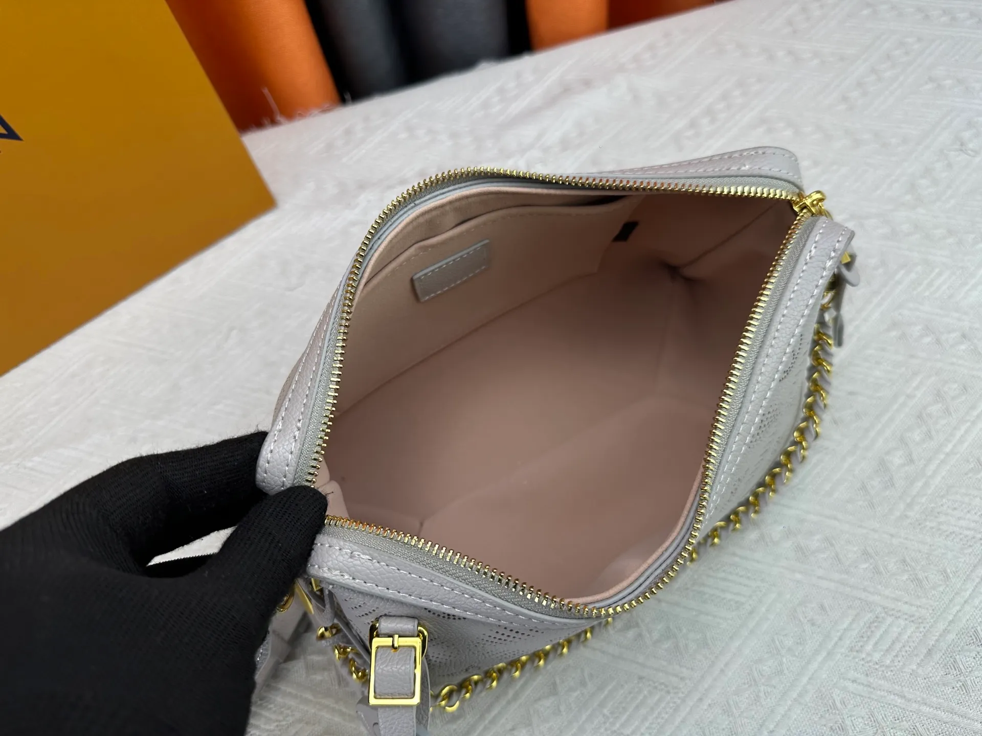 P260 Upgraded original M13157 M24255 M24114 This Hand It All small handbag is made of cow leather to interpret the brand's Bloom elements. The perforated Monogram pattern is integrated with floral imagery, and the classic style is upgraded with contrasting branding. The inner patch pocket is convenient for storing mobile phones, and the woven chain allows for flexible switching between cross-body or shoulder wear. Dimensions: 29.0 x 18.0 x 13.0 cm (length x height x width)
