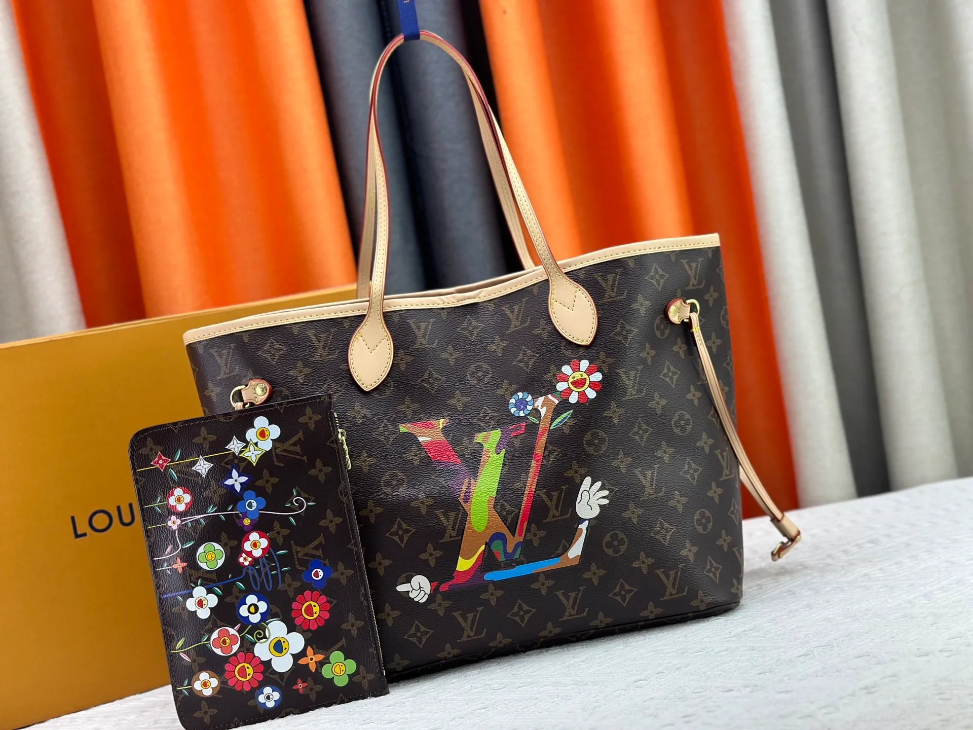 P260 Upgraded original M13675 M13271 M40995 This medium-sized Neverfull handbag is from the Louis Vuitton x Takashi Murakami reissue series. It uses Monogram canvas to create a spacious configuration, and then uses the smart Monogram floral pattern to interpret the artist's "ultra-flat" aesthetic style. Cowhide leather outlines the upper edge, handles and side straps, while the fabric lining incorporates colorful stripes. An interior zip pocket and a removable storage bag complete the functional design. Dimensions: 31.0 x 28.0 x 14.0 cm (length x height x width)