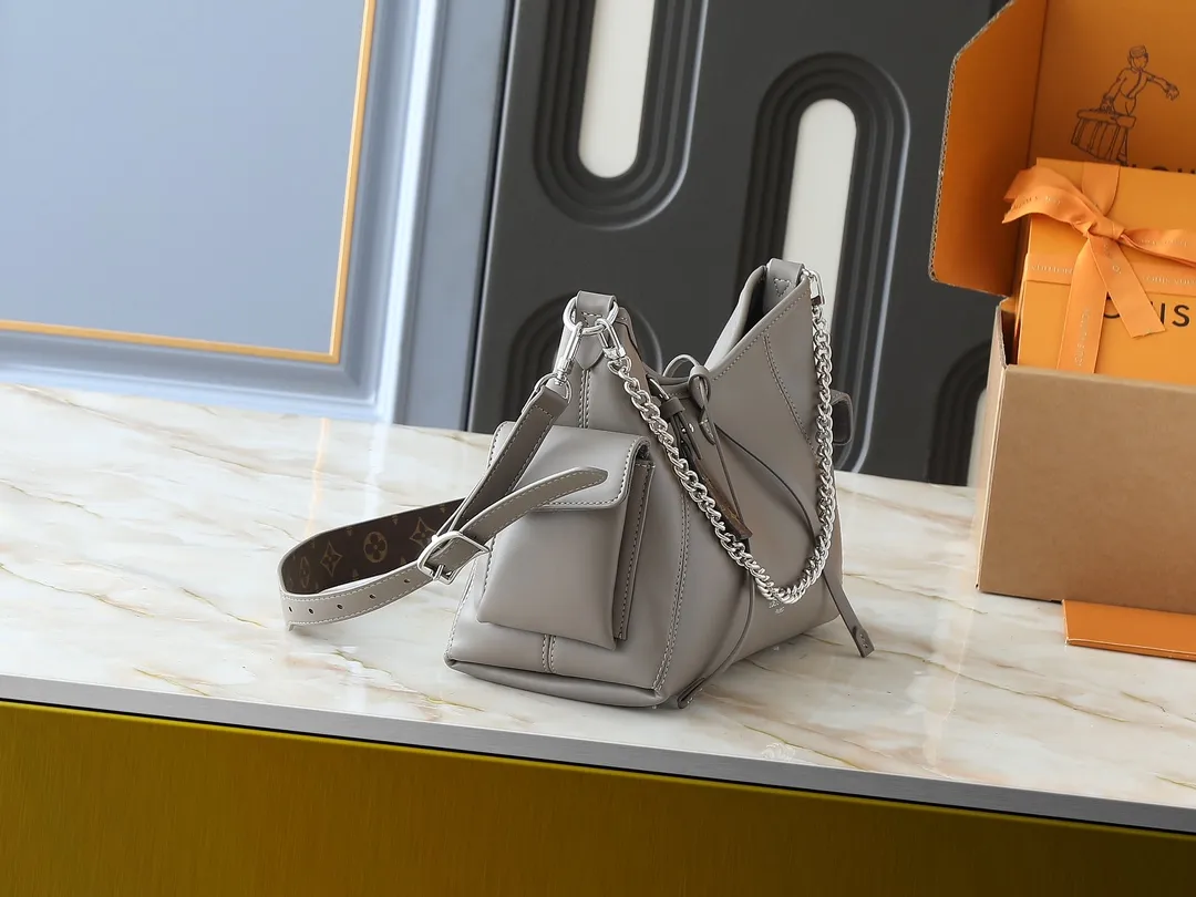 💰260💰Upgraded from the original M25143 M24861 M12583 M12579 M12919 M13105 This small CarryAll Cargo handbag is made of soft sheep leather with a fashionable micro-wrinkle effect, and is paired with polished metal parts and a lazy configuration on a deep background, making it a perfect choice for day and night occasions. The detachable shoulder strap and chain strap allow for a variety of styling possibilities. Dimensions: 23 x 15 x 33.5 cm (H x W x Length)