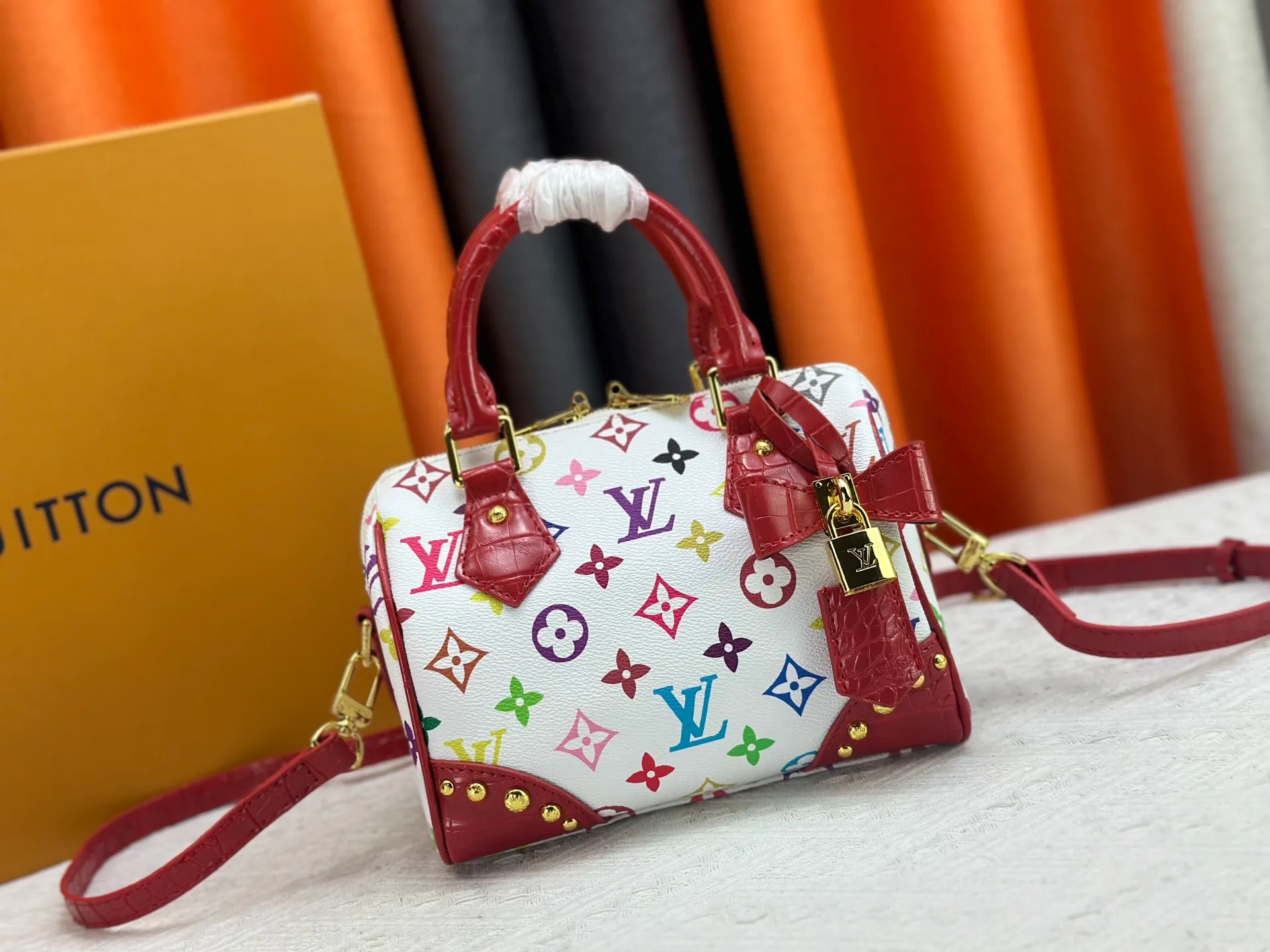 P260 Upgraded original crocodile pattern M13365 M58953 M46234 M46222 Speedy Bandoulière 20 handbag is made of soft coated canvas, and the full-length Monogram pattern is traced in colorful rainbow tones, highlighting the smart style of the Louis Vuitton x Murakami reissue series. The Toron handle and detachable shoulder strap are constructed of cow leather, the metal corners recall classic luggage elements, and the bow-shaped key bag and padlock add brand touches. Dimensions: 20.5 x 13.5 x 12.0 cm (length x height x width)