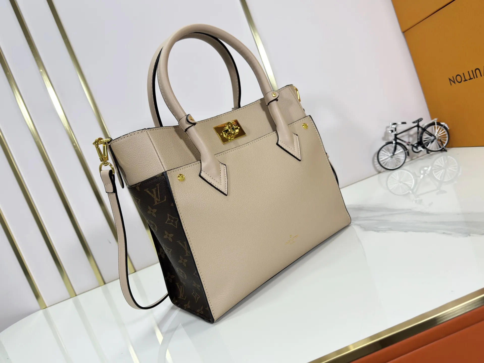 P340 upgraded original M53826 M53825 M53824 M53823On My Side handbag shows the elegant fusion of calfskin and classic Monogram canvas. Contrasting canvas shapes the large outer pocket, creating a trompe l'oeil effect as if two handbags merge into one. Plenty of space can easily accommodate office needs, and the adjustable shoulder strap allows for a cross-body style. Dimensions: 30.5 x 24.5 x 14 cm (Length x Height x Width) - Calfskin and Monogram coated canvas - Cowhide leather trim - Microfiber lining - 2 top handles for hand or elbow carry - Adjustable shoulder strap for shoulder or cross-body wear - Lock closure - 2 outer pockets with magnetic closure - Zip pocket - 1 patch pocket