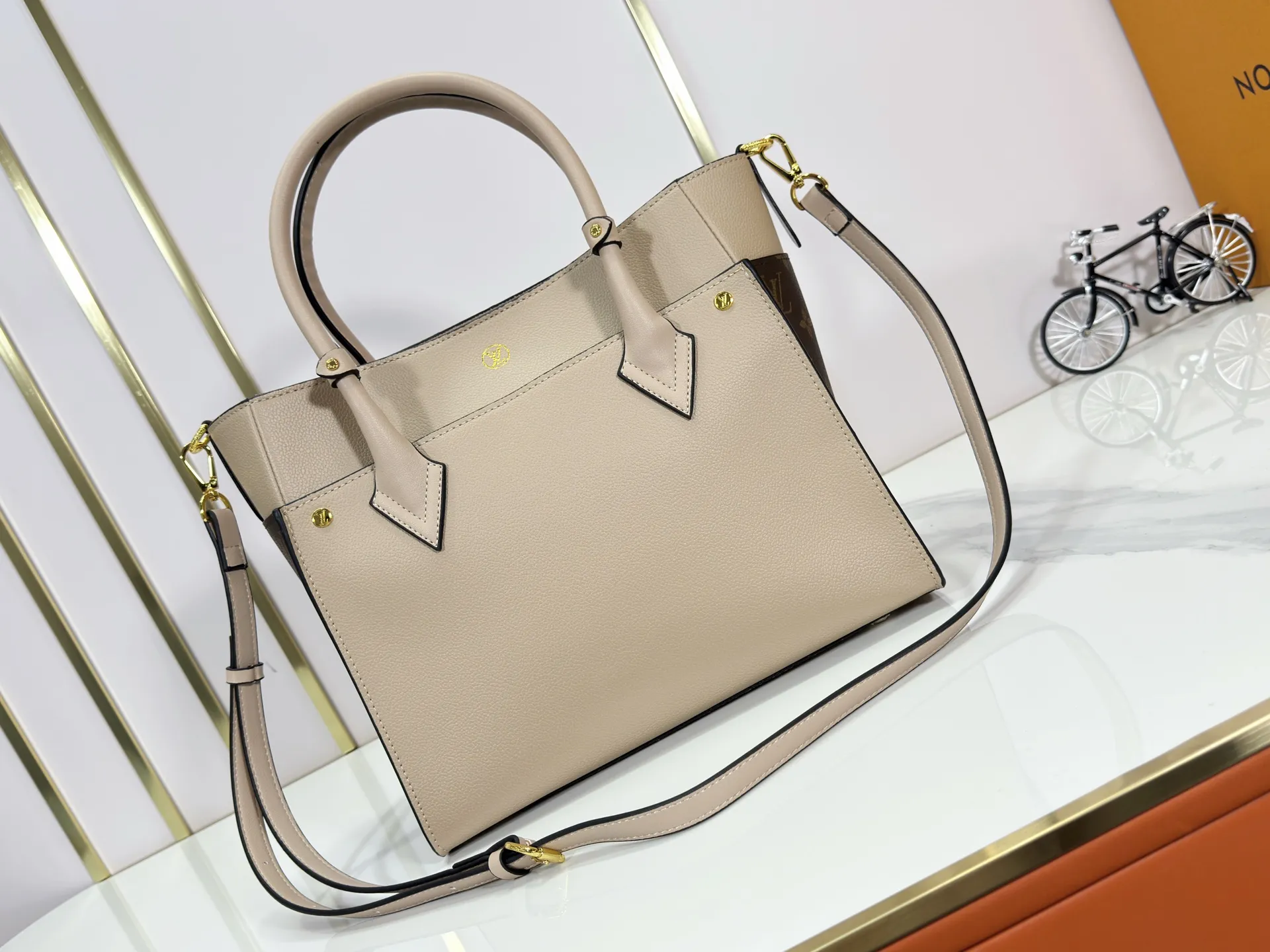 P340 upgraded original M53826 M53825 M53824 M53823On My Side handbag shows the elegant fusion of calfskin and classic Monogram canvas. Contrasting canvas shapes the large outer pocket, creating a trompe l'oeil effect as if two handbags merge into one. Plenty of space can easily accommodate office needs, and the adjustable shoulder strap allows for a cross-body style. Dimensions: 30.5 x 24.5 x 14 cm (Length x Height x Width) - Calfskin and Monogram coated canvas - Cowhide leather trim - Microfiber lining - 2 top handles for hand or elbow carry - Adjustable shoulder strap for shoulder or cross-body wear - Lock closure - 2 outer pockets with magnetic closure - Zip pocket - 1 patch pocket
