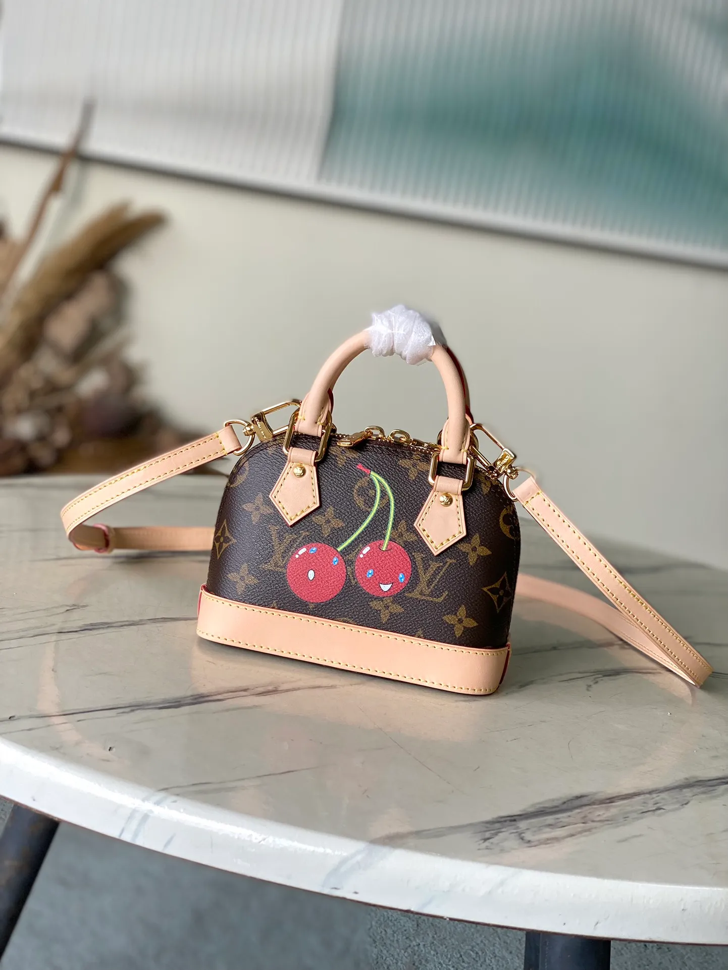 💰960 Top Original Order M13416 (82717 Cherry) This compact Nano Alma is embellished with the interesting cherry pattern of the replica Louis Vuitton x Murakami series, highlighting the playful style of the handbag. The handbag is made of Monogram coated canvas and trimmed with natural cowhide leather. It also features many classic brand elements, including top handles and a detachable shoulder strap with adjustable length, allowing it to be carried in a variety of ways. The bag is suitable for storing daily essentials, including a small wallet and a large smartphone.  18 x 12 x 8 cm (length x height x width)