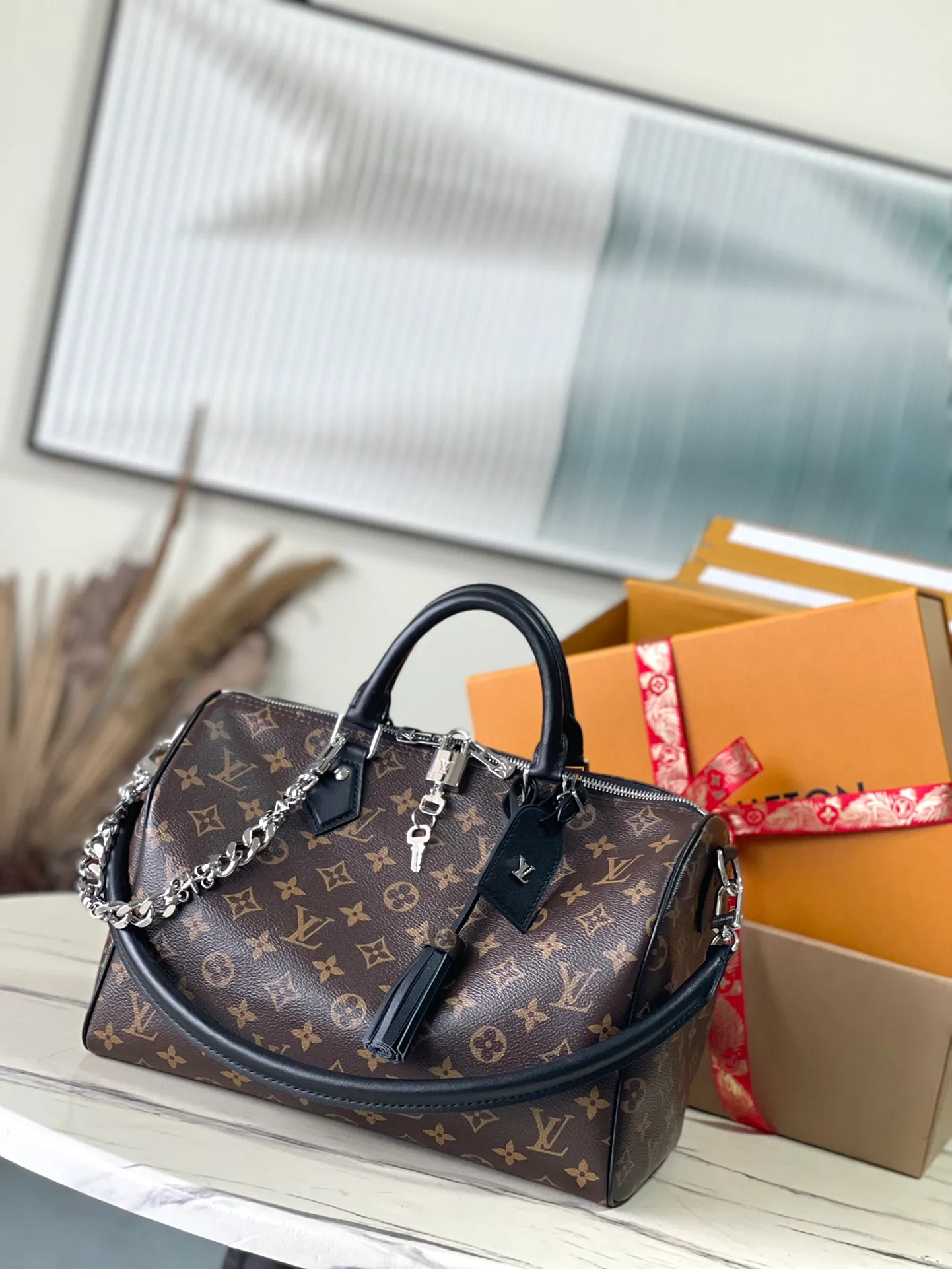 💰1100 The top original M12243 Speedy Soft 30 Dark handbag makes a good travel companion with its eye-catching style. The Monogram coated canvas bag is integrated with leather trim and a gothic chain. The ample structure has a zippered pocket inside to keep your passport and other important items safe. The brand name and tassels tell the exquisite details, and the Toron handle adds a novel touch. Dimensions: 30 × 21 × 17 cm