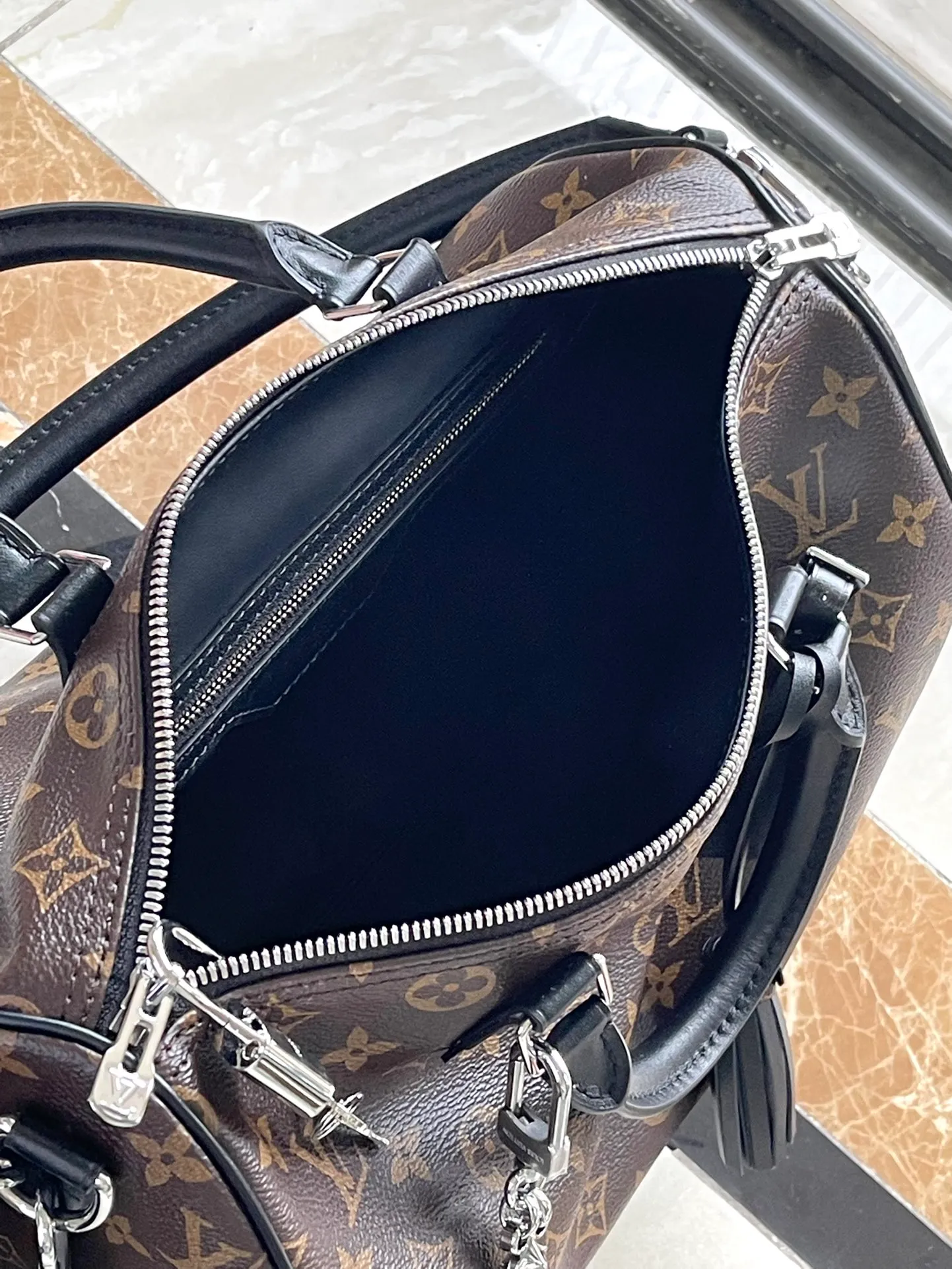 💰1100 The top original M12243 Speedy Soft 30 Dark handbag makes a good travel companion with its eye-catching style. The Monogram coated canvas bag is integrated with leather trim and a gothic chain. The ample structure has a zippered pocket inside to keep your passport and other important items safe. The brand name and tassels tell the exquisite details, and the Toron handle adds a novel touch. Dimensions: 30 × 21 × 17 cm