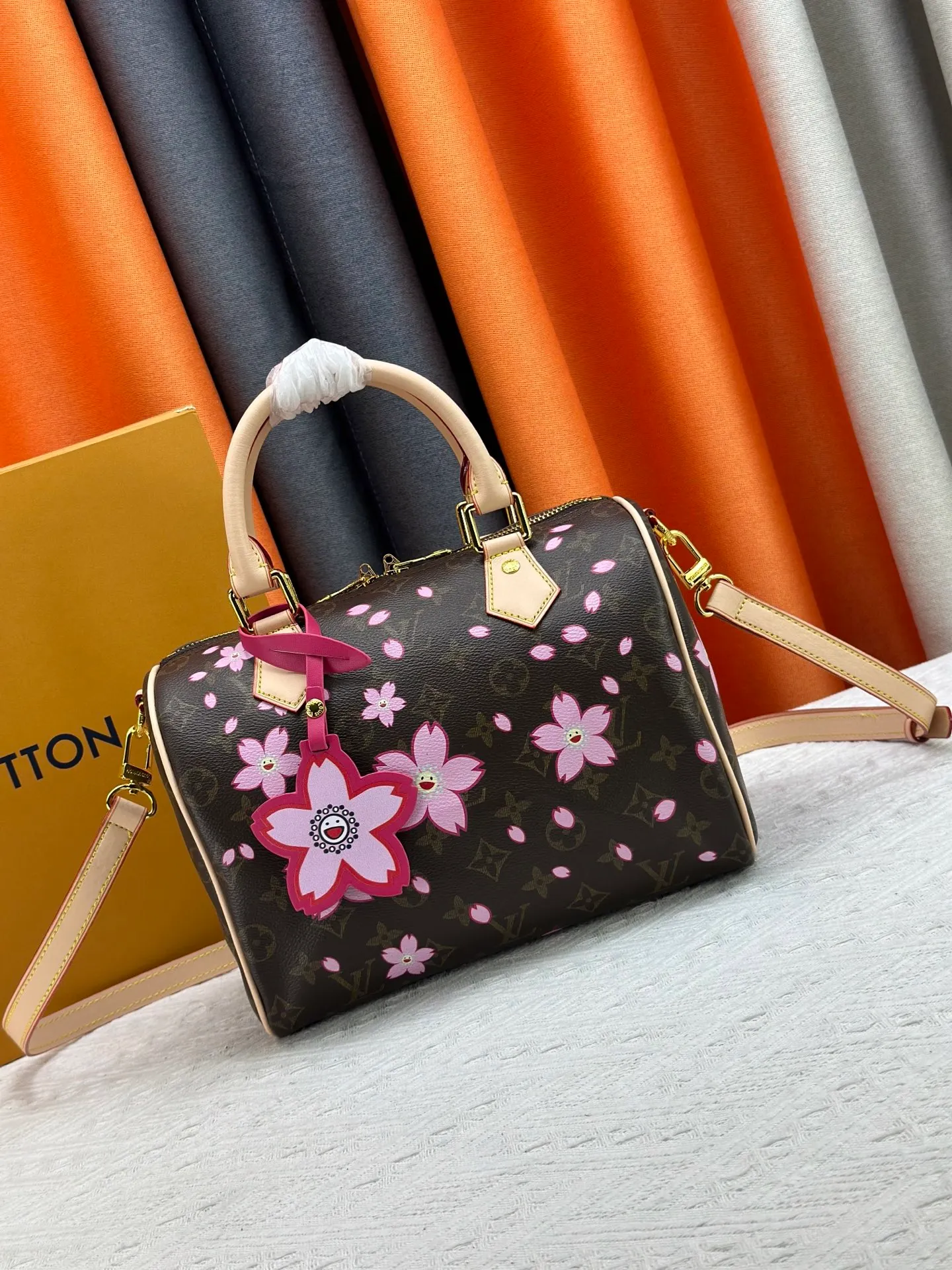 P260 M14174 This Speedy Bandoulière 25 handbag is from the Louis Vuitton x Takashi Murakami replica series. It incorporates the brand's classic Monogram coating into Takashi Murakami's vivid Cherry Blossom pattern, and then continues the same element into the removable bag decoration. Cow leather constructed Toron handles and removable leather shoulder strap, dual zippers and padlock keep personal belongings safe and secure.  19 x 15 x 25 cm (H x W x L) Cherry Blossom Monogram coated canvas Cow leather trim Removable Cherry Blossom trim Textile lining Metal hardware Double zip closure Internal zip pocket Padlock Holds a 6.7" smartphone, Victorine short wallet, headphones and keys Shoulder strap: removable, not adjustable Half-length strap: 44.0 cm Handles: Double handles