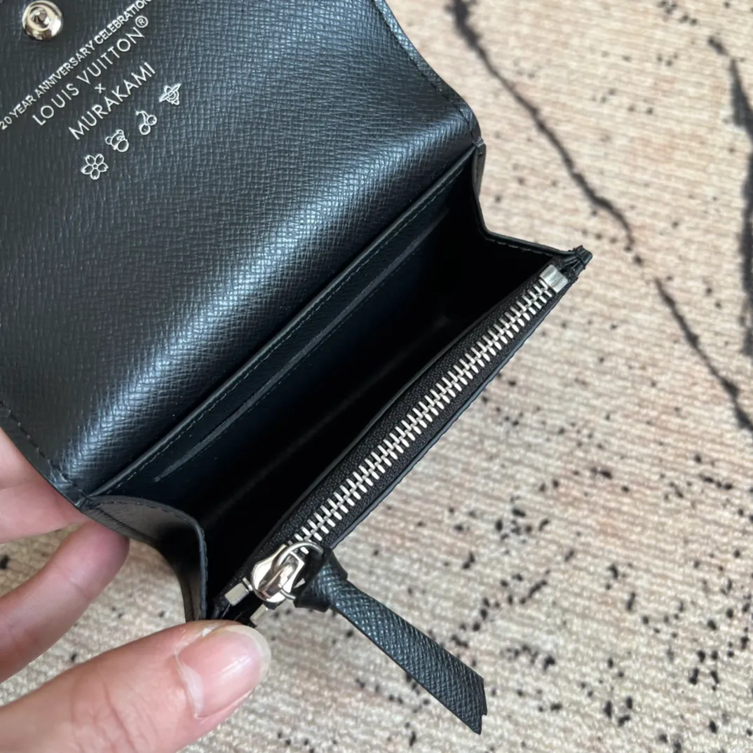 Factory price 300 Top original order M13399 black color This Rosalie coin purse is from the Louis Vuitton x Takashi Murakami reissue series. The Monogram coated canvas is dipped in vibrant colors, subtly paying tribute to the distinctive style of Japanese artist Takashi Murakami. The compact construction features a rounded flap and snap closure, and the interior houses a zipped coin pocket with Monogram pullers. 8 x 2.5 x 11 cm (height x width x length)