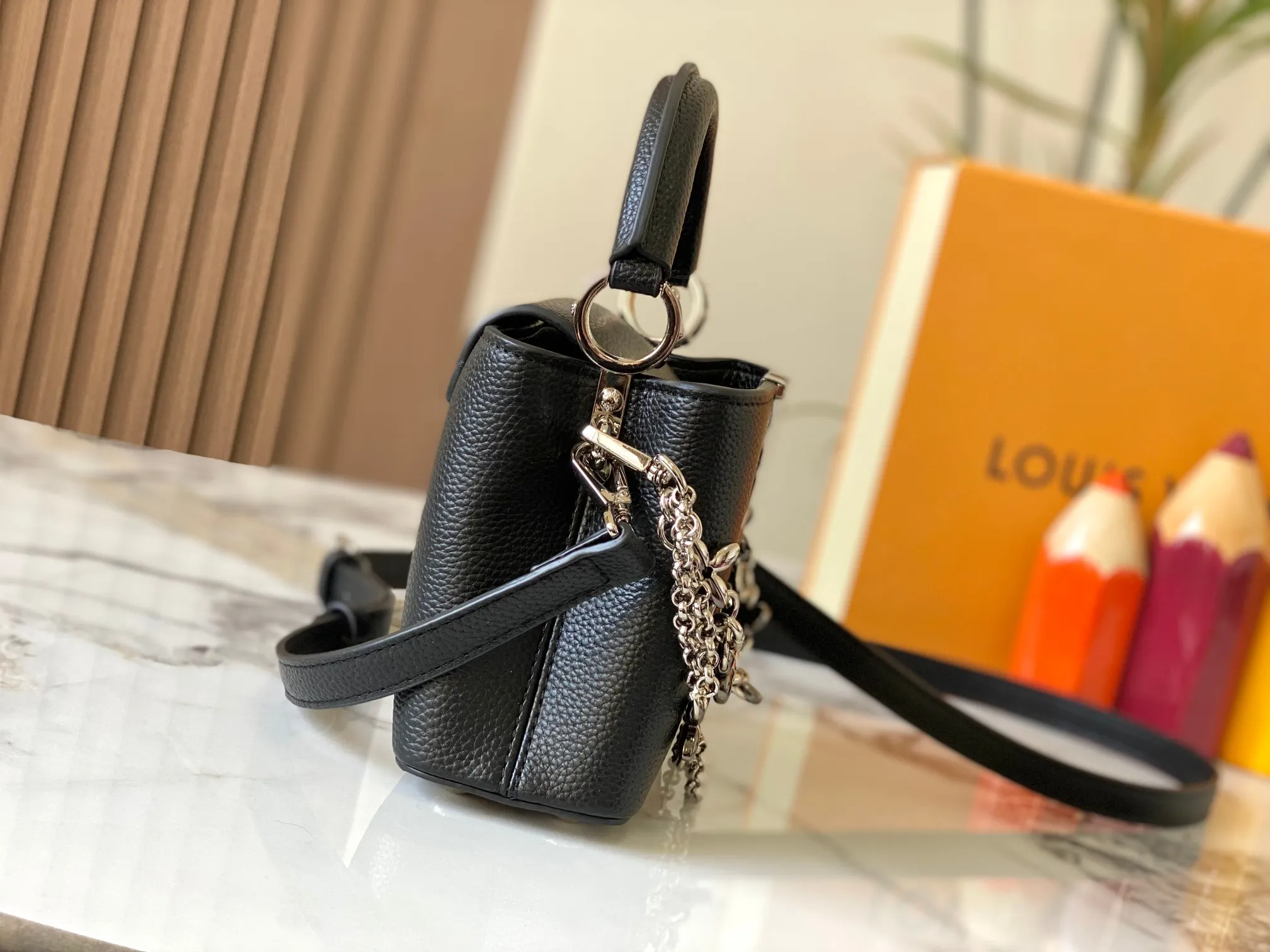 P480 [Guangzhou top quality original version] M26351 Black Silver This modern version of Capucines mini is made of timeless Taurillon leather and equipped with a jewelry-inspired Infinity chain. The bag is decorated with double galvanized metal parts, including the iconic Monogram floral pattern, and the LV Initials logo created with sunburst technology, creating a sundial-like light and shadow effect. The bag has multiple pockets and a detachable shoulder strap, allowing it to be carried on one shoulder or across the body. 14 x 8 x 21 cm (height x width x length)