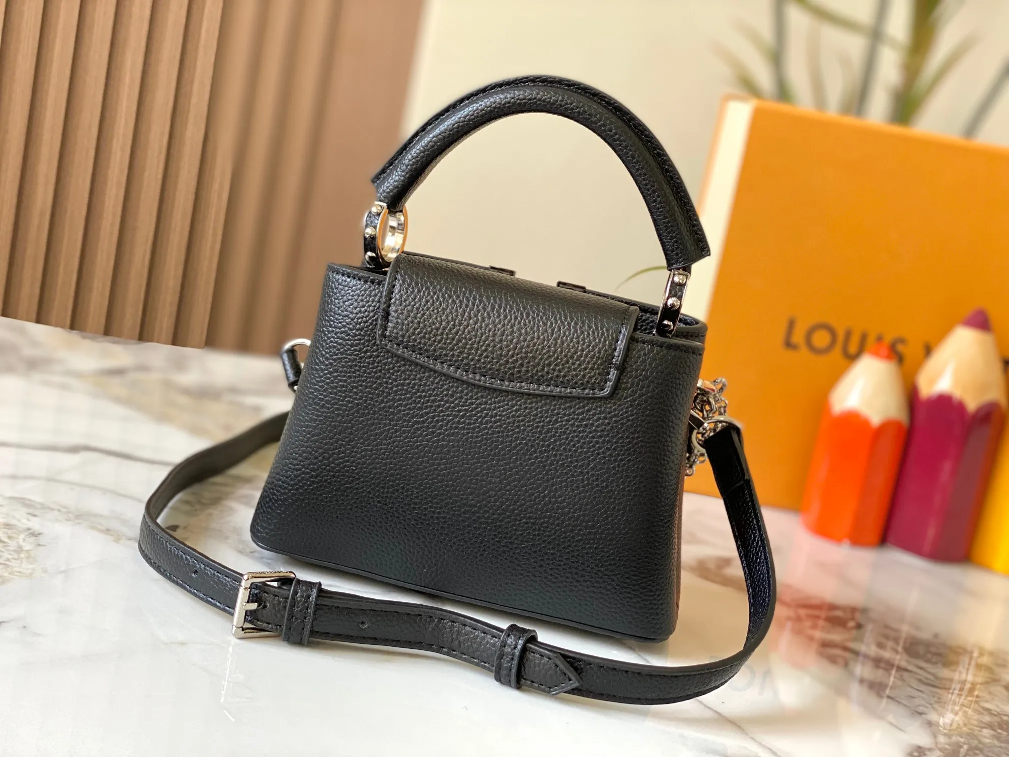 P480 [Guangzhou top quality original version] M26351 Black Silver This modern version of Capucines mini is made of timeless Taurillon leather and equipped with a jewelry-inspired Infinity chain. The bag is decorated with double galvanized metal parts, including the iconic Monogram floral pattern, and the LV Initials logo created with sunburst technology, creating a sundial-like light and shadow effect. The bag has multiple pockets and a detachable shoulder strap, allowing it to be carried on one shoulder or across the body. 14 x 8 x 21 cm (height x width x length)