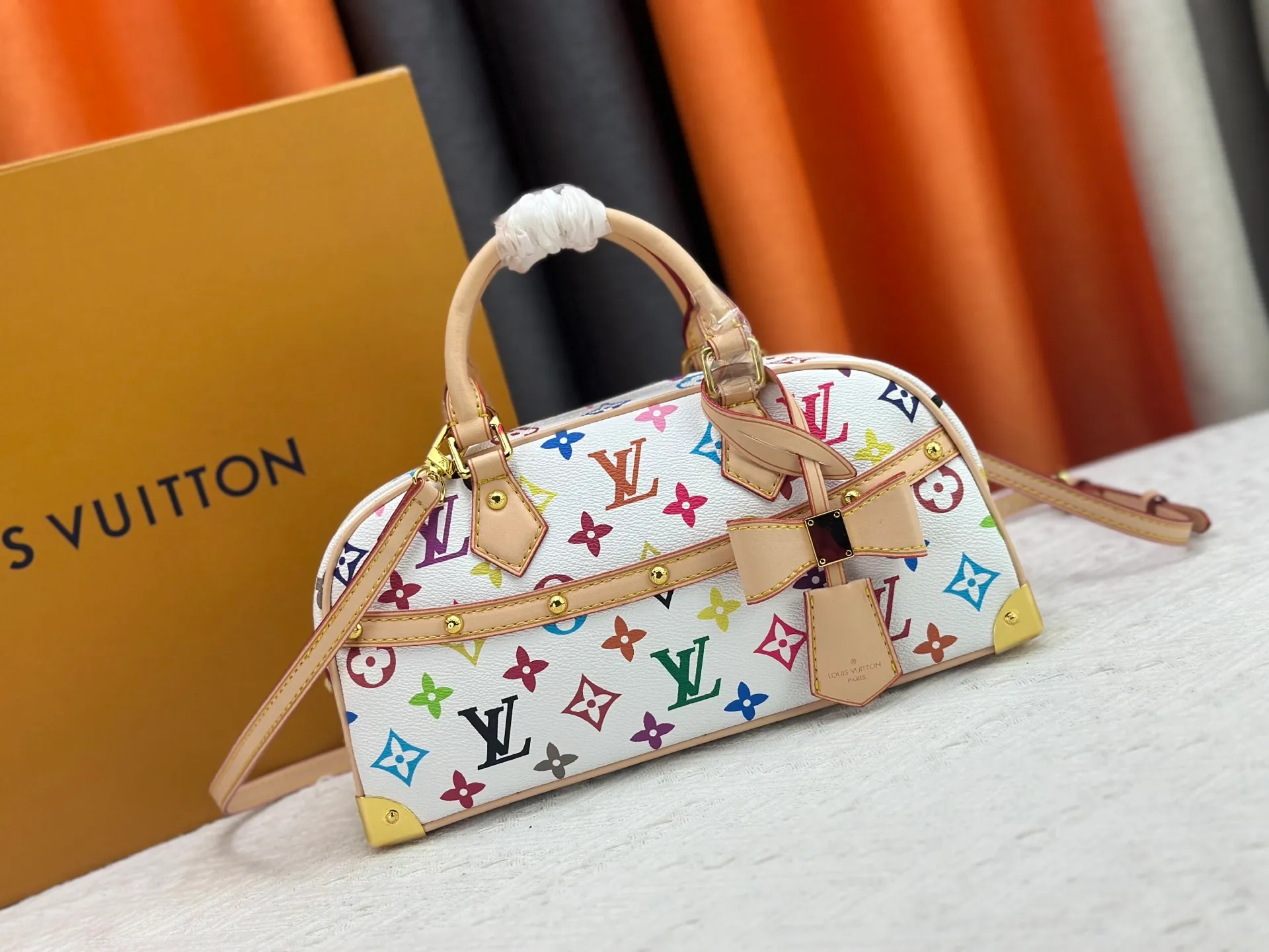 P280 Upgraded Original M13084 This Handbag East West handbag is from the Louis Vuitton x Takashi Murakami reissue series, using the artist's signature rainbow tones to trace the full-length Monogram pattern. Sleek horizontal construction lines the top handle, studded side straps, detachable and adjustable shoulder strap and LV x TM key holder, with cowhide leather details and sophisticated corners that nod to the brand's traditional luggage. Dimensions: 27.0 x 14.0 x 10.0 cm (length x height x width)
