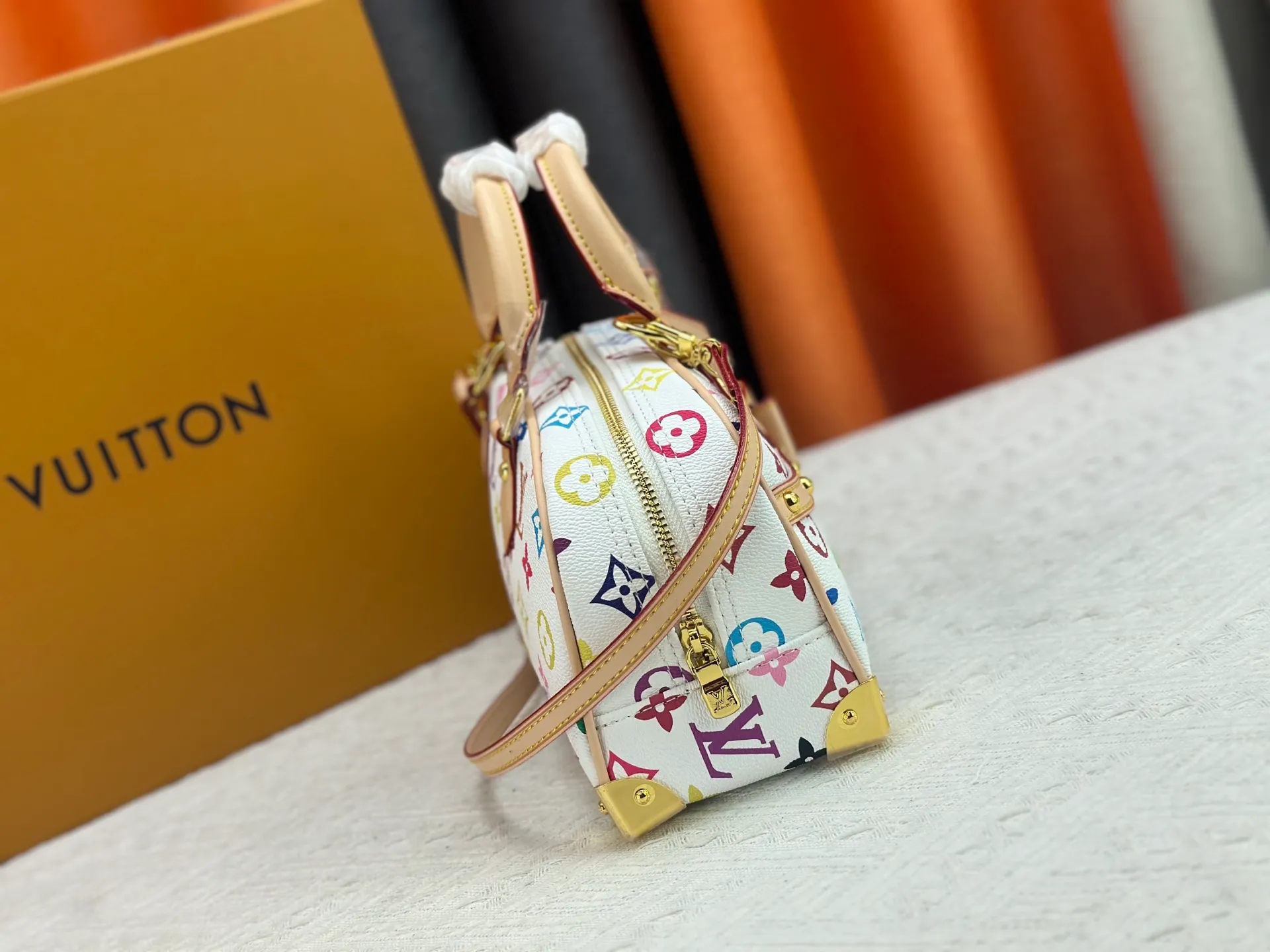 P280 Upgraded Original M13084 This Handbag East West handbag is from the Louis Vuitton x Takashi Murakami reissue series, using the artist's signature rainbow tones to trace the full-length Monogram pattern. Sleek horizontal construction lines the top handle, studded side straps, detachable and adjustable shoulder strap and LV x TM key holder, with cowhide leather details and sophisticated corners that nod to the brand's traditional luggage. Dimensions: 27.0 x 14.0 x 10.0 cm (length x height x width)