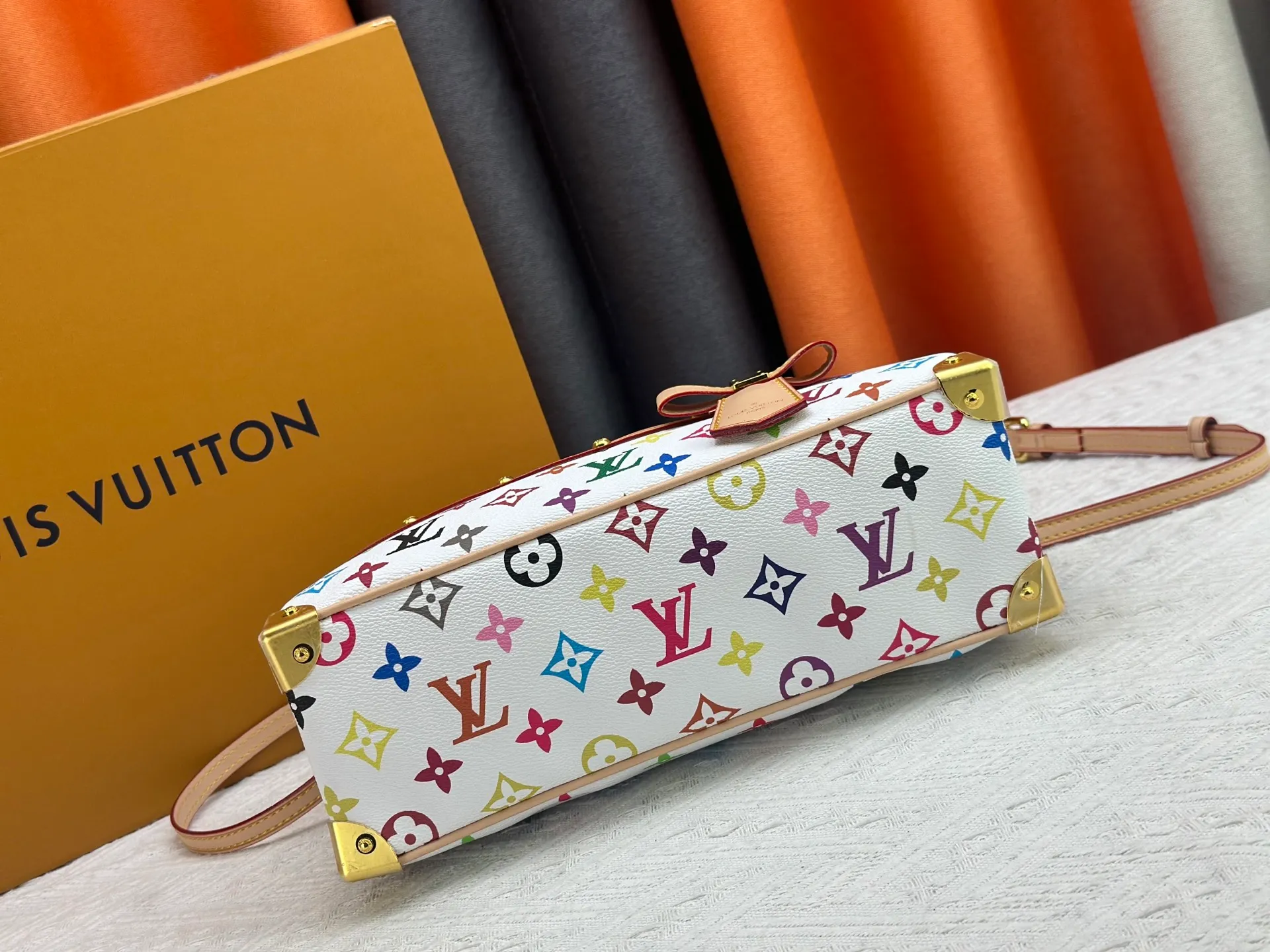 P280 Upgraded Original M13084 This Handbag East West handbag is from the Louis Vuitton x Takashi Murakami reissue series, using the artist's signature rainbow tones to trace the full-length Monogram pattern. Sleek horizontal construction lines the top handle, studded side straps, detachable and adjustable shoulder strap and LV x TM key holder, with cowhide leather details and sophisticated corners that nod to the brand's traditional luggage. Dimensions: 27.0 x 14.0 x 10.0 cm (length x height x width)