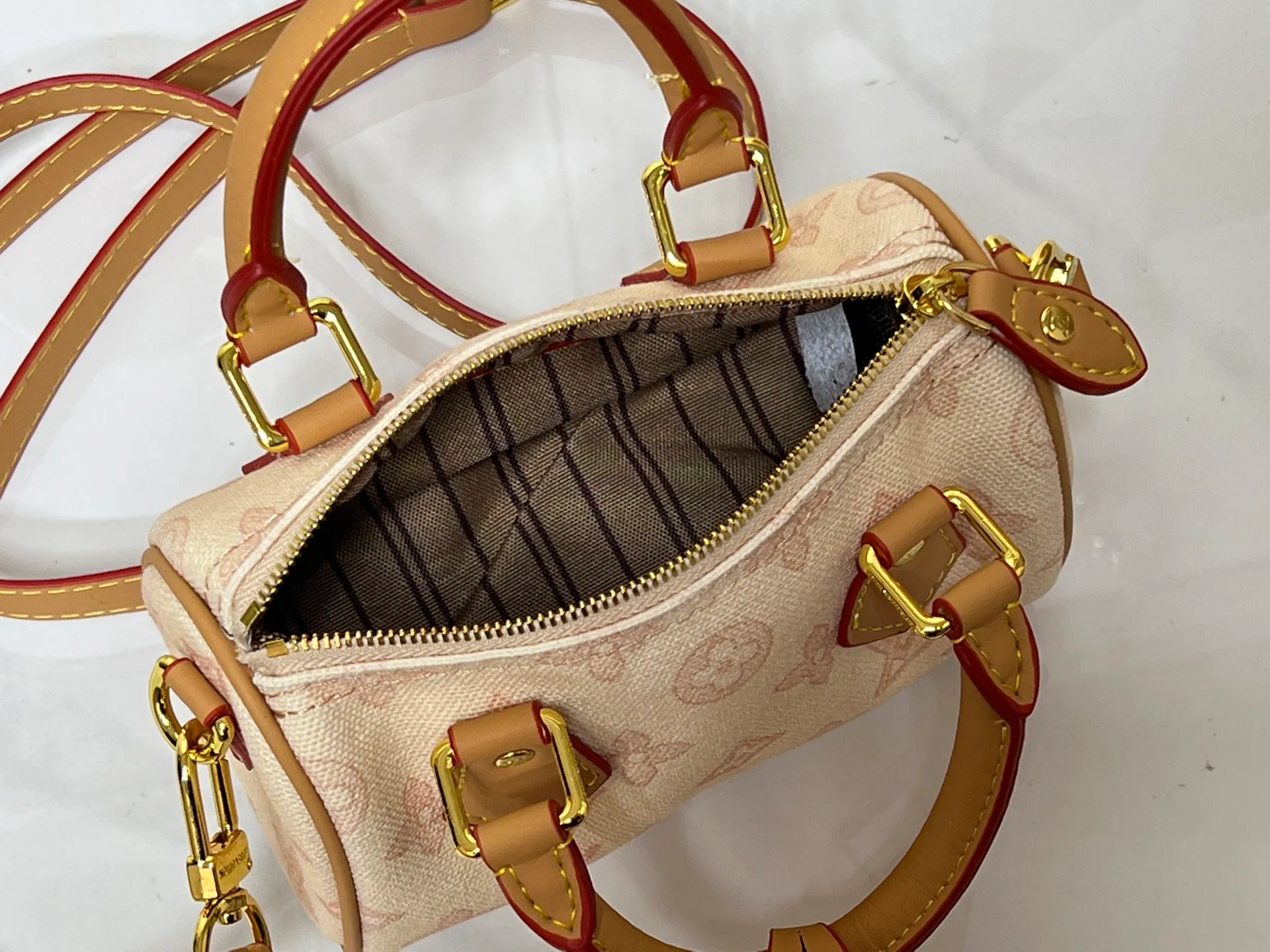 Batch 240💰M28322 Red M28323 M27610 M81085 [Exclusive background shot] This Nano Speedy handbag condenses the configuration of Louis Vuitton's classic Speedy handbag. It is made of Monogram canvas with distressed cow leather details and dazzling metal parts, making it easy to carry with you for daily needs. The handles and removable and adjustable shoulder strap allow for a variety of styling possibilities. 16.0 x 10.0 x 7.5 cm (L x H x W) • Monogram coated canvas • Cow leather trim • Metal hardware • Zipper closure • Space to store daily necessities such as a 6.1-inch smartphone, card holder and lipstick • Shoulder strap: removable, adjustable • Half-length strap: 45.5 cm • Half-length strap adjustable to: 54.0 cm • Handle: Double handle