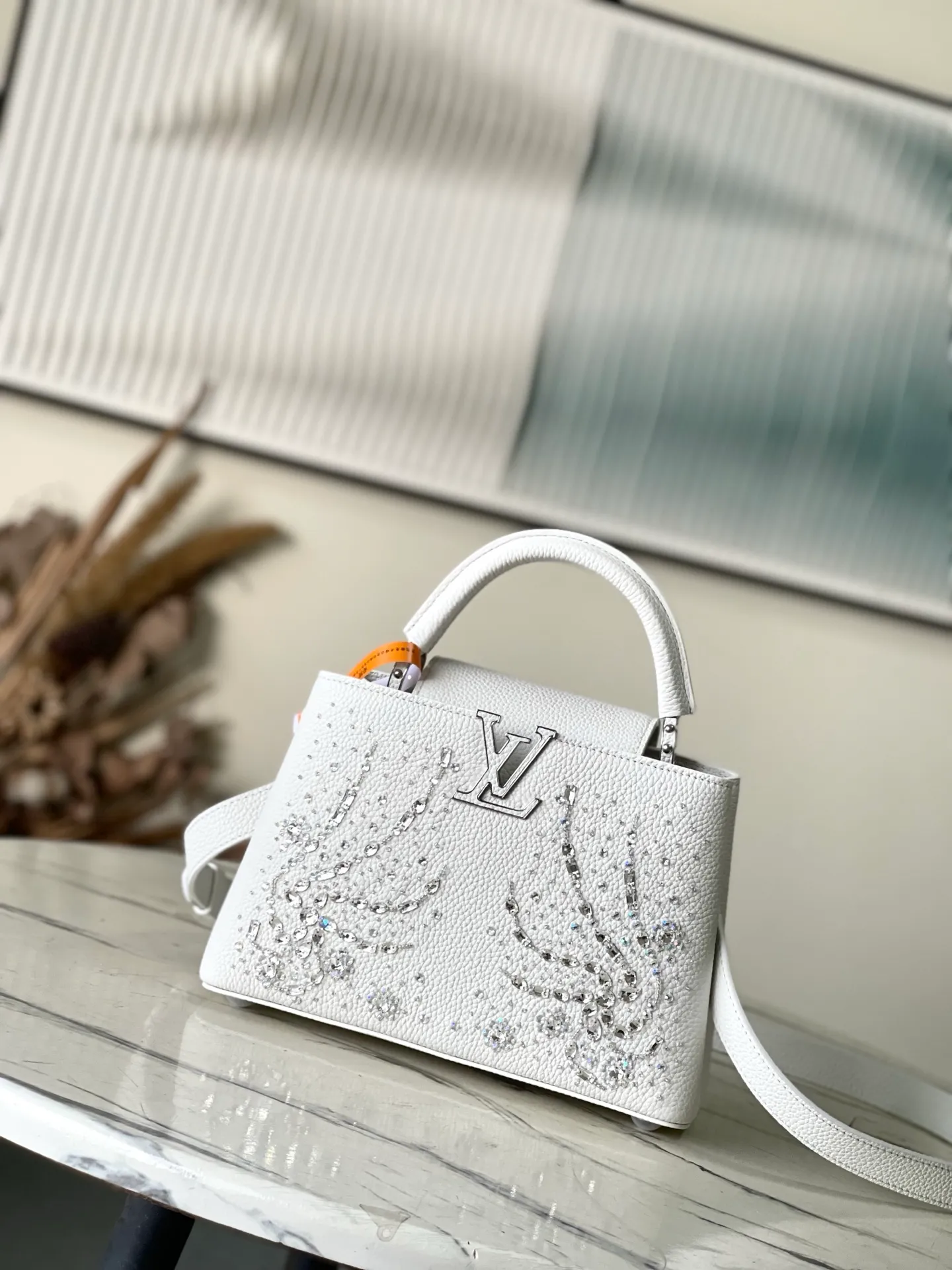 💰2900 "Special Grade Original Leather" M25934 White Small As part of the "Extraordinary Series", this Capni mini bag has been redesigned with exquisite embroidery technology. It's made from calfskin and embellished with shimmering sequins in a romantic floral pattern and finished with gold-toned hardware. The backpack design provides a separated interior space and features the iconic LV initials as a tribute to the brand's exquisite craftsmanship. Dimensions: 27 x 17.3 x 9cm