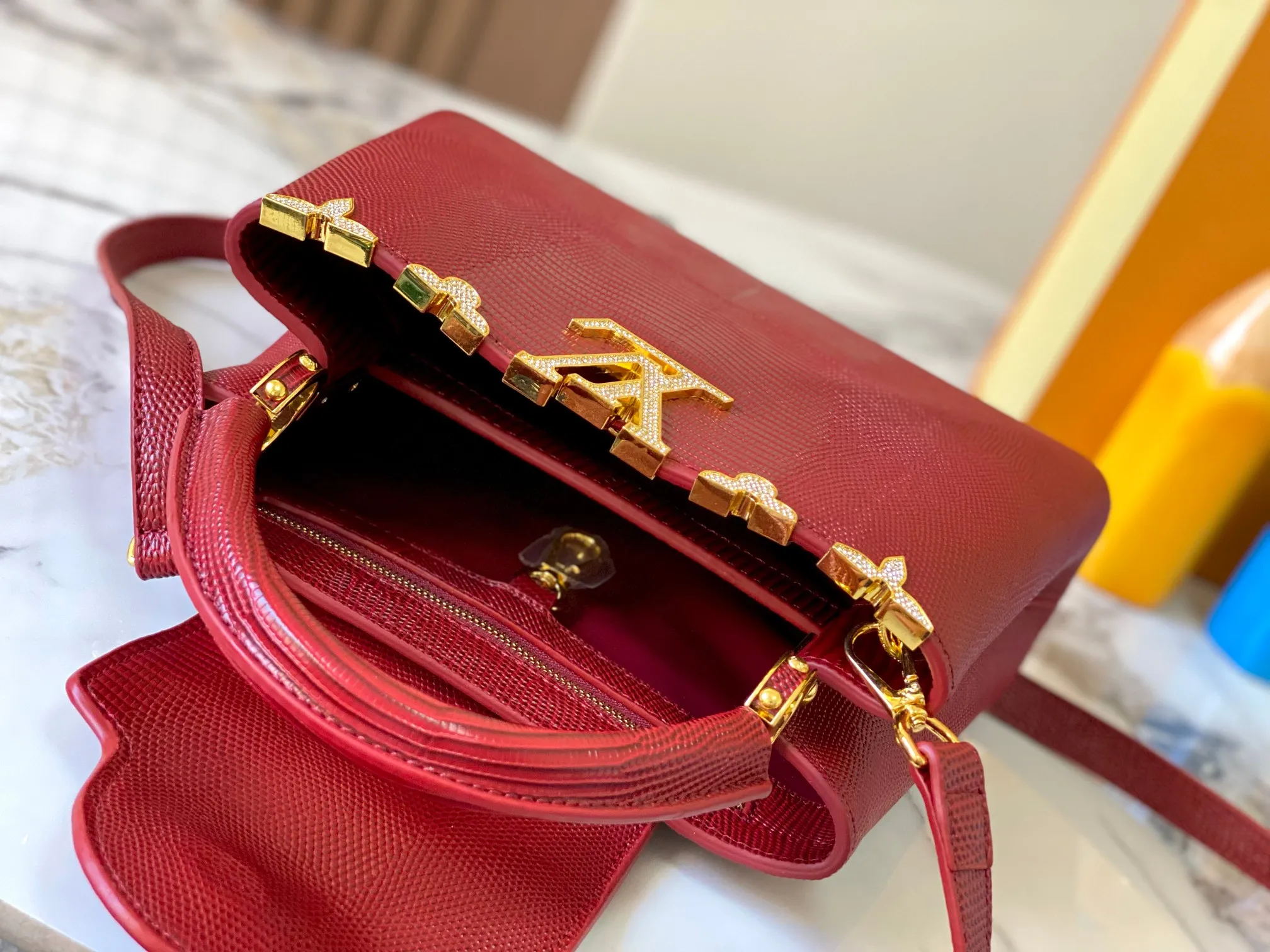 Top original P460 Guangzhou-made M12297 maroon lizard skin with gold and diamond corolla 🔺This CapucinesBB handbag exquisitely combines elegant lizard skin outer layer, delicate sheepskin lining and gleaming metal parts. The iconic flip cover achieves two styles. The LV logo can be read on the inside and the Monogram flower blooms on the outside. It lights up an eye-catching corner for evening occasions and adds a personalized atmosphere to the wardrobe. Shine gorgeous style in day and night occasions.  Detailed features 27 x 18 x 9 cm (length x height x width)