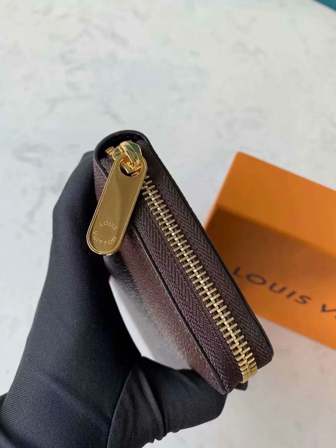 P140M60017 Brown painted small single-pull wallet This Zippy wallet is made of Damier Ebene canvas, with a new lining design and four credit card slots, making it convenient and practical.  Detailed features 19.5x 10.5x 2.5 cm (L x H x W) - Louis Vuitton specially coated canvas - Grained cowhide leather lining - Calfskin trim - Shiny gold-tone hardware - 12 credit card slots - Zippered coin pocket - Open note compartment - 2 internal patch pockets - 3 large paneled compartments - Zip closure