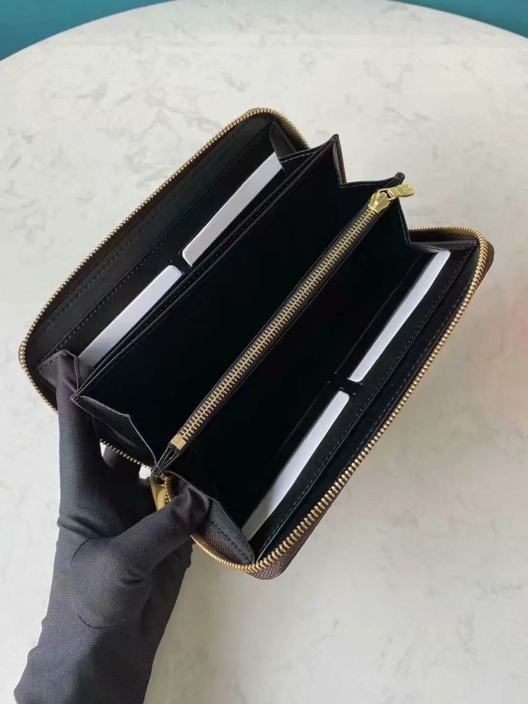 P140M60017 Brown painted small single-pull wallet This Zippy wallet is made of Damier Ebene canvas, with a new lining design and four credit card slots, making it convenient and practical.  Detailed features 19.5x 10.5x 2.5 cm (L x H x W) - Louis Vuitton specially coated canvas - Grained cowhide leather lining - Calfskin trim - Shiny gold-tone hardware - 12 credit card slots - Zippered coin pocket - Open note compartment - 2 internal patch pockets - 3 large paneled compartments - Zip closure