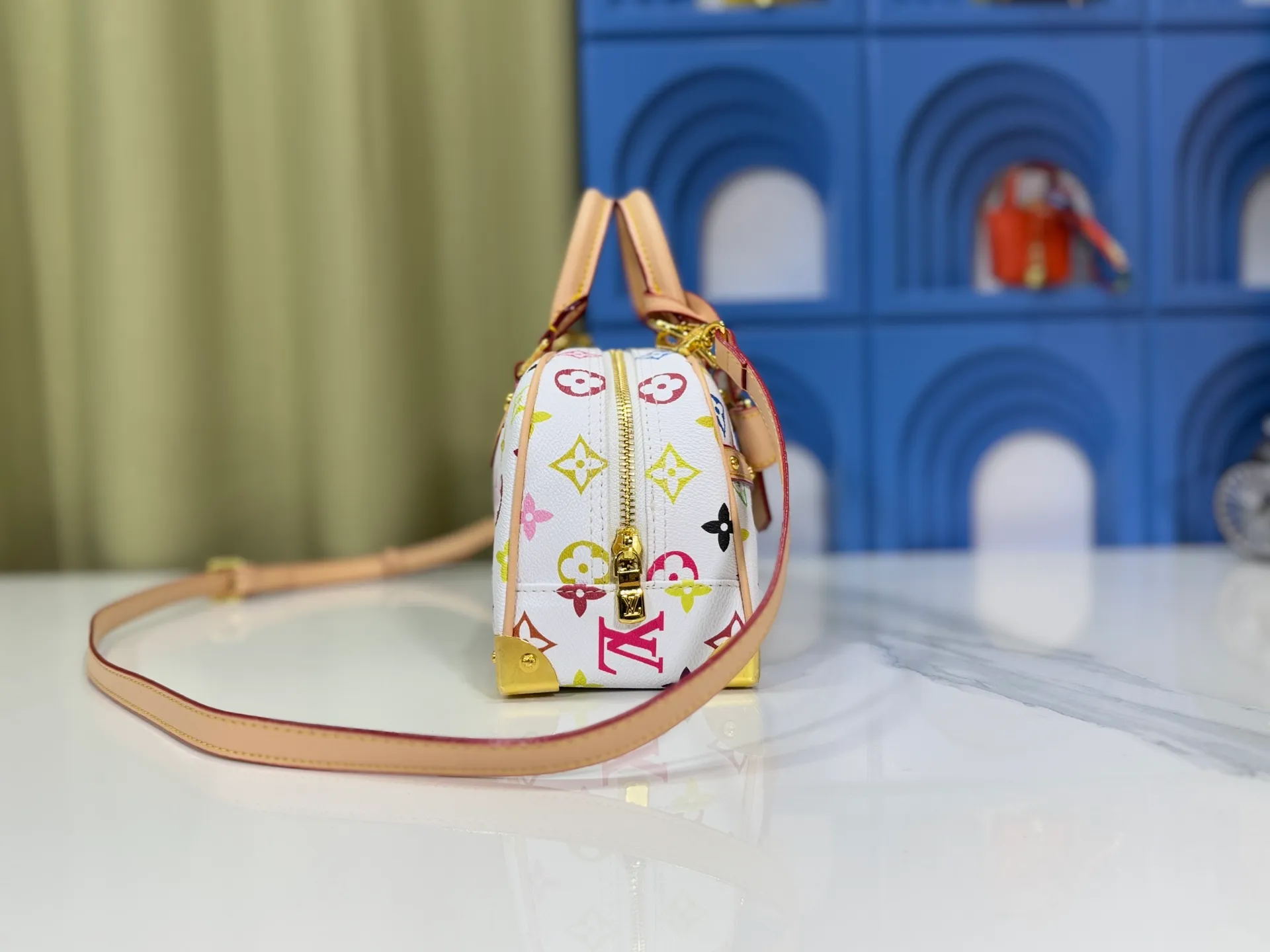 P300 Upgraded Original M13084 This Handbag East West handbag is from the Louis Vuitton x Takashi Murakami reissue series, using the artist's signature rainbow tones to trace the full-length Monogram pattern. Sleek horizontal construction lines the top handle, studded side straps, detachable and adjustable shoulder strap and LV x TM key holder, with cowhide leather details and sophisticated corners that nod to the brand's traditional luggage. Dimensions: 27.0 x 14.0 x 10.0 cm (length x height x width)
